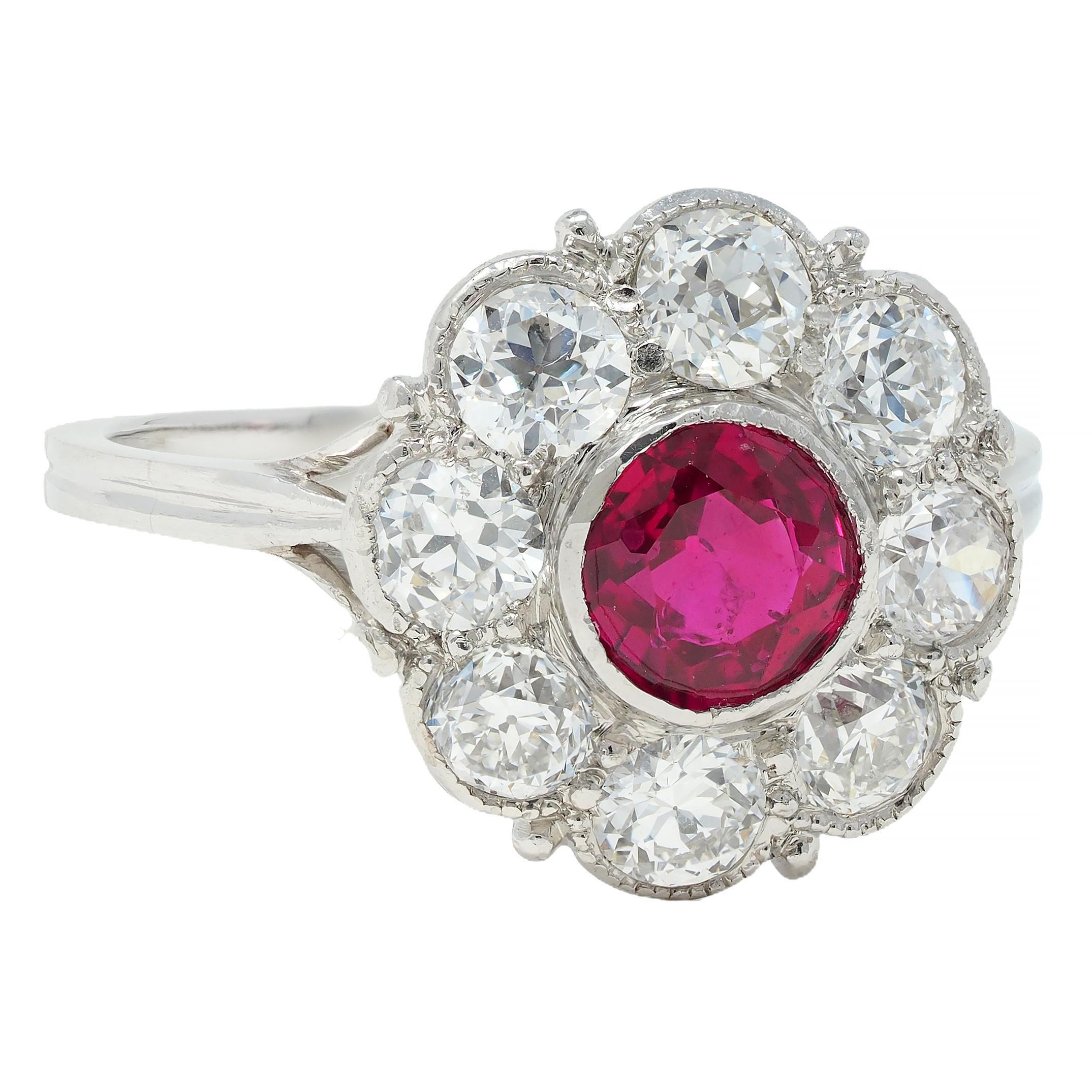 Centering a round cut ruby weighing approximately 0.78 carat - transparent vibrant red
Natural Burmese in origin and displaying no indications of heat treatment
Bezel set with a halo surround of old European cut diamonds 
Weighing approximately 1.28