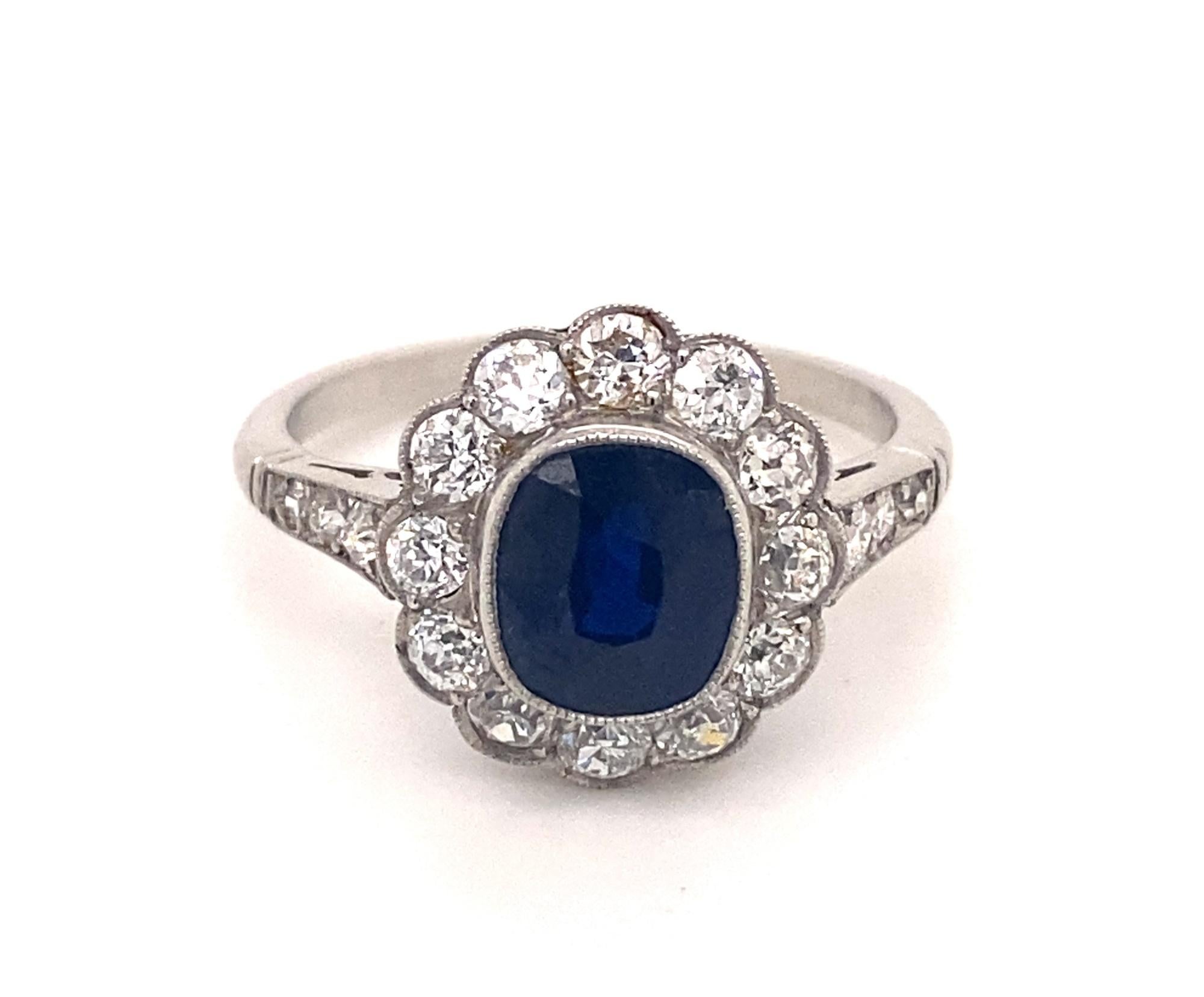 This is a beautiful vintage art deco style ring set with a 2.06 sapphire with a halo of diamonds in platinum.  The setting has an intricate filigree design in the gallery.  The sapphire is natural deep blue color with good clarity.  There are 18 old