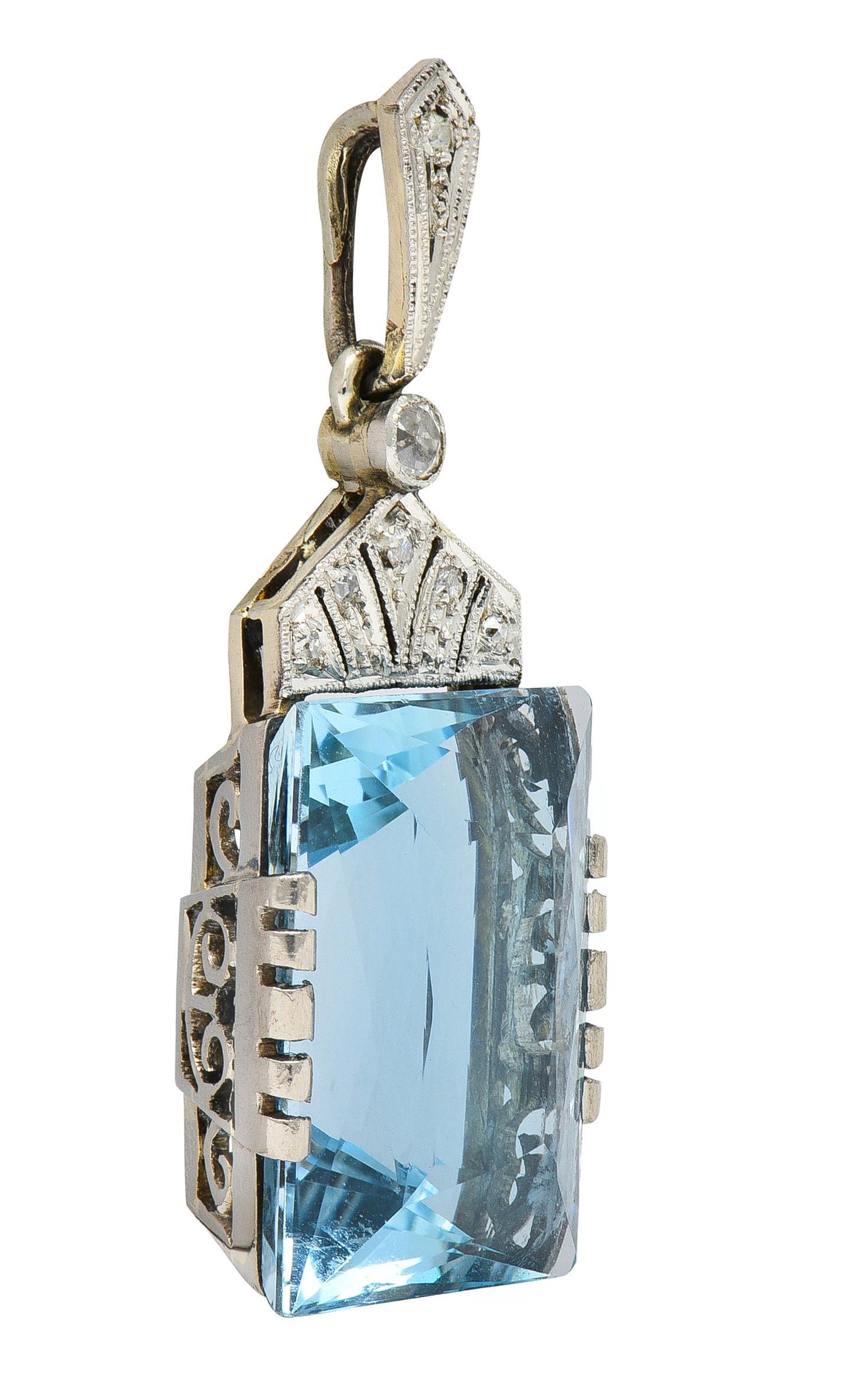 Featuring a mixed rectangular cut aquamarine weighing approximately 20.50 carats 
Transparent light blue in color and set with grooved tabs in scroll motif mounting
Set below a pierced geometric fanning motif suspending from kite-shaped bale
Bead