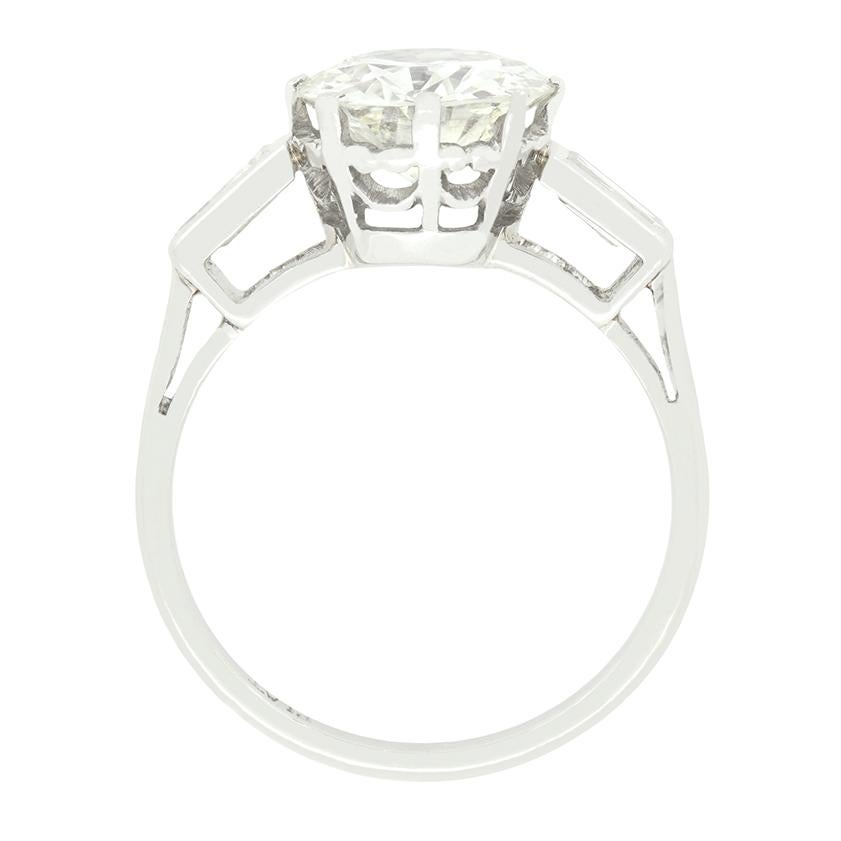 Sitting central to this classic Art Deco solitaire ring is a stunning 2.10 carat old cut diamond. The diamond truly sparkles with a colour of J to K and clarity of VS1, and is claw set into platinum to highlight its whiteness. Flanking the main