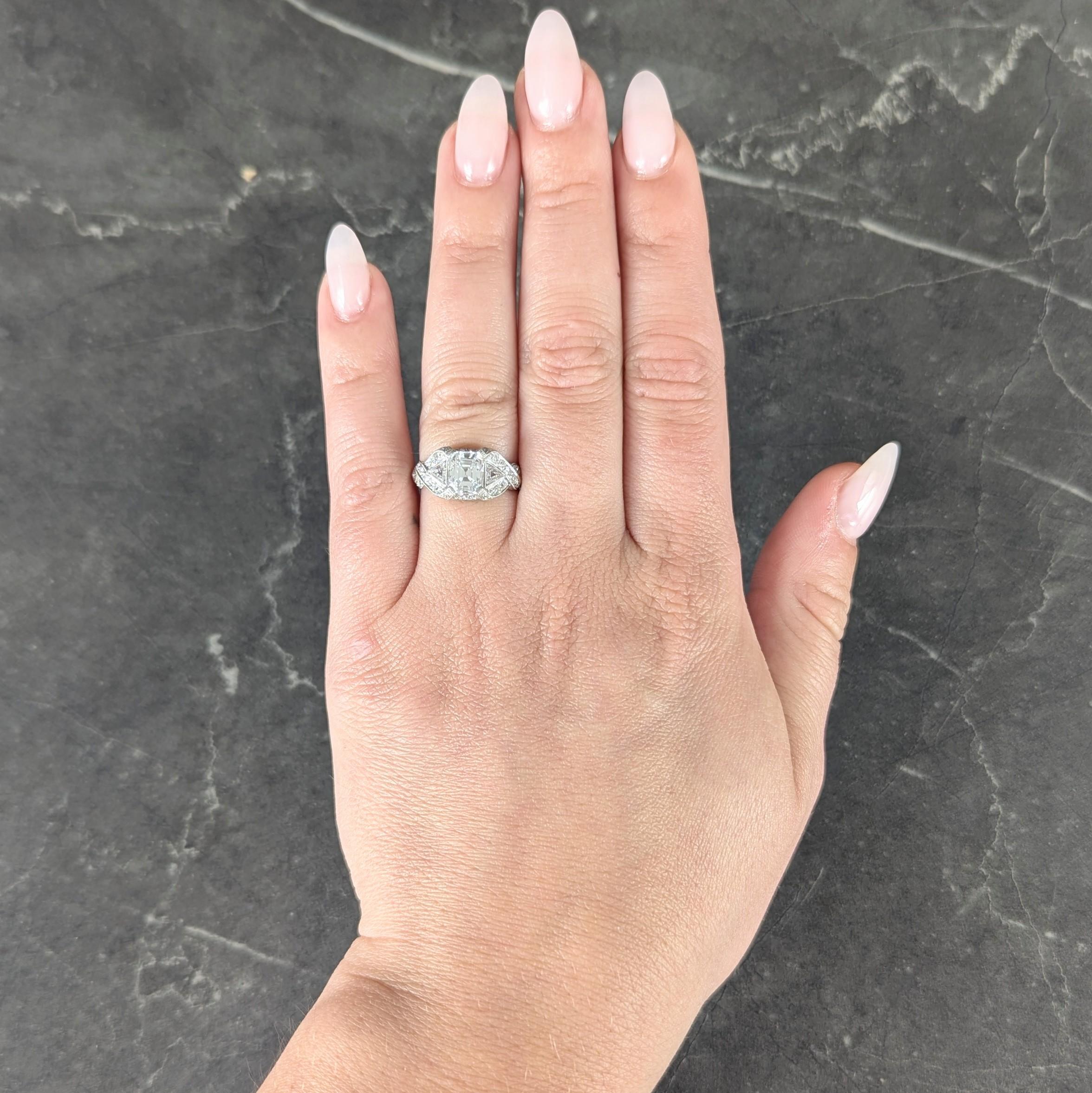 Centering an Asscher cut diamond weighing approximately 1.20 carats - H color with VS2 clarity
Set at corners via tab-like prongs and flanked by bezel set trillion cut diamonds
Weighing approximately 0.30 carat total - H color with VS2 and SI2