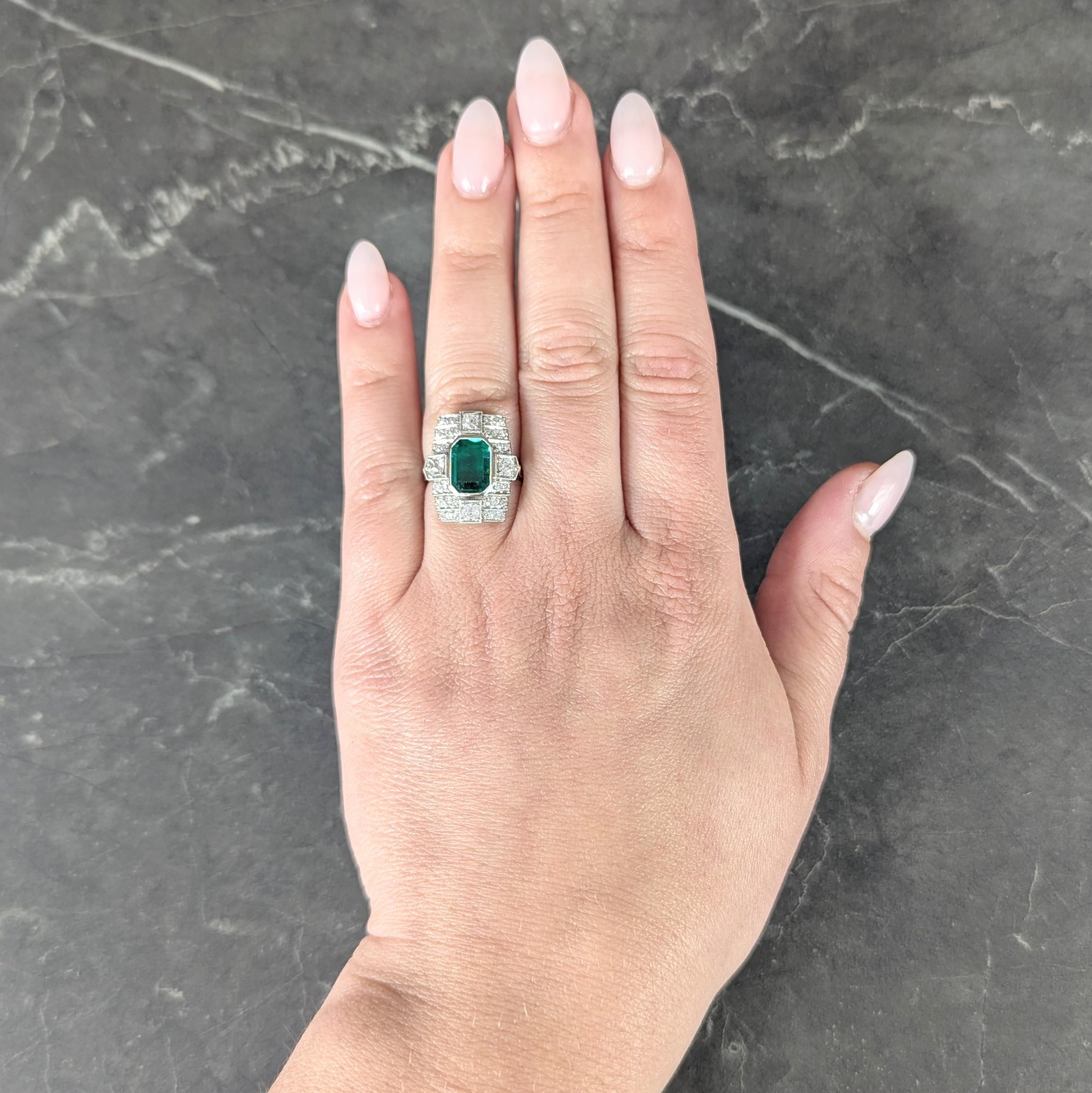 Centering an emerald cut emerald weighing approximately 1.43 carats - transparent medium green
Natural Colombian in origin and displaying minor traditional treatment
Bezel set with old mine cut diamonds bead set at cardinal points
Weighing