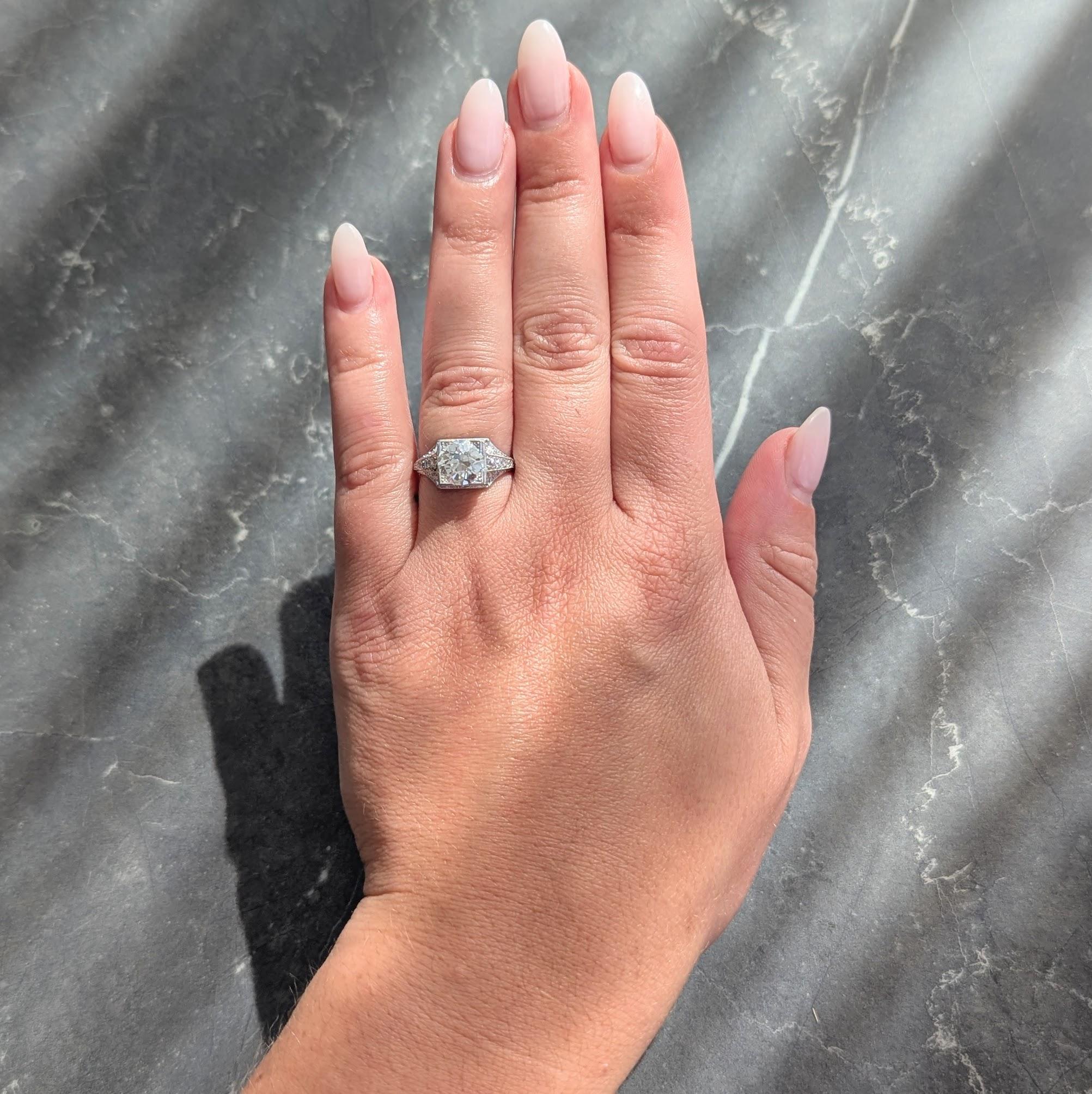 In der Mitte ein Diamant im alten europäischen Schliff mit einem Gewicht von etwa 1,87 Karat - Farbe K und Reinheit VS2
Besetzt mit drei Perlen in einem quadratischen Kopf mit durchbrochener geometrischer Galerie-Einfassung
Perlenbesatz mit