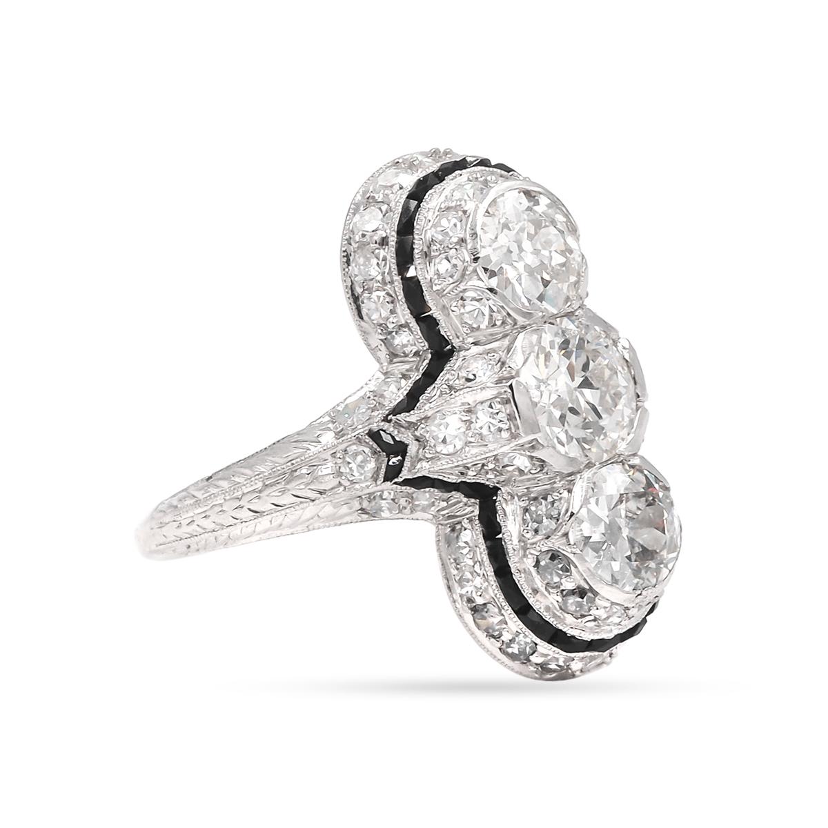 Exquisite Art Deco era 3-stone ring composed of platinum. Featuring 3 Old European Cut diamonds weighing 1.50 carats in total. Accented by 57 Old Single Cut diamonds weighing 0.77 carats in total. Surrounded by a border of French Calibre Cut Black