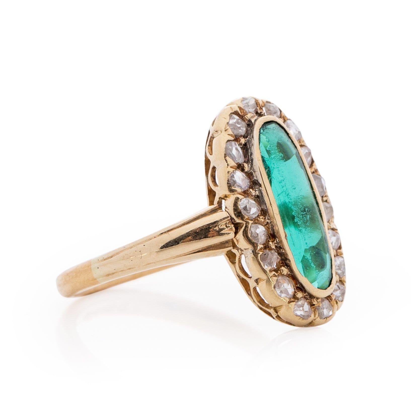 This showstopper is simple, timeless and elegant all at once. Crafted in beautiful 22K Yellow Gold sits a breathtaking elongated green gem, the hue of the gem is vibrant and full of life. Surrounding the gem is a halo of 18 single cut diamonds,