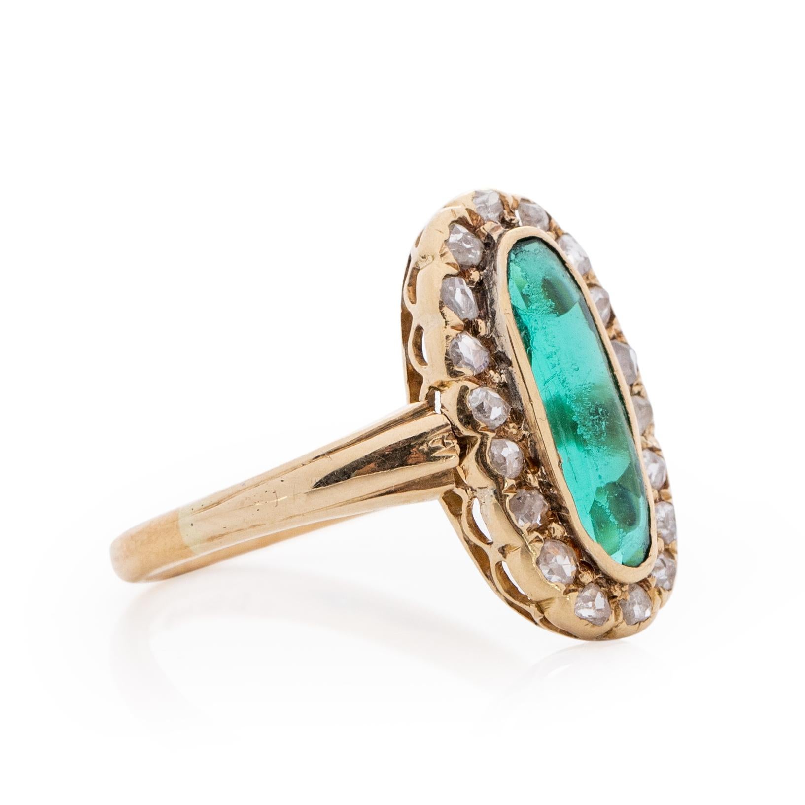 This showstopper is simple, timeless and elegant all at once. Crafted in beautiful 22K Yellow Gold sits a breathtaking elongated green gem, the hue of the gem is vibrant and full of life. Surrounding the gem is a halo of 19 single cut diamonds,