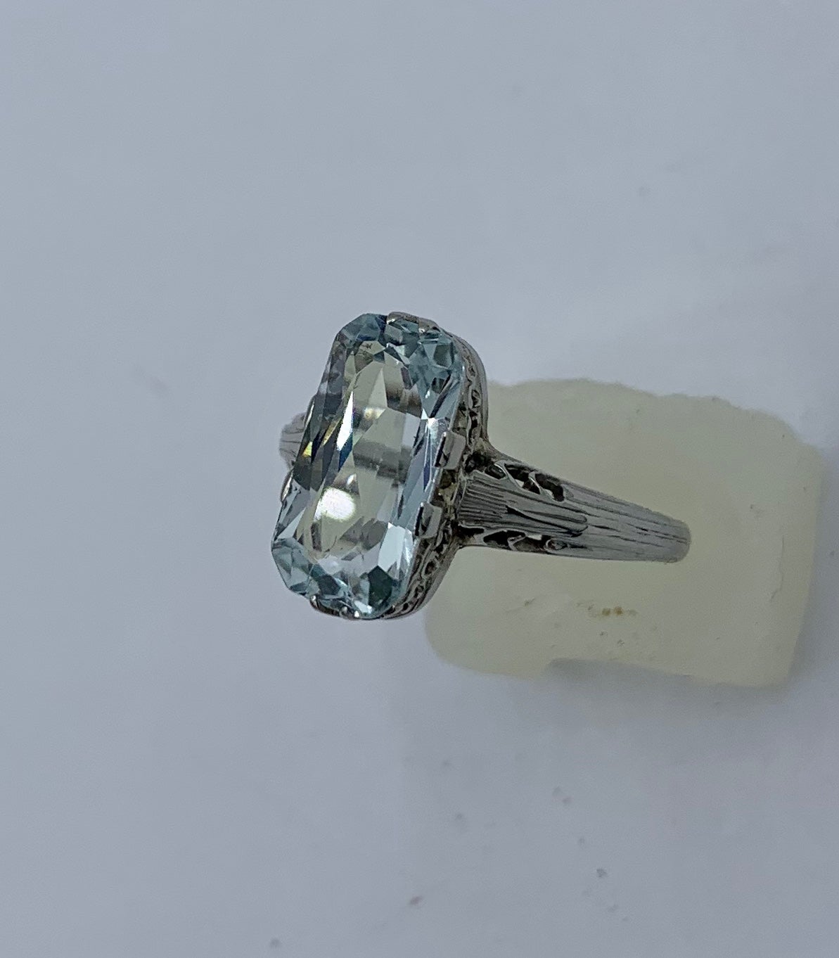 This is a stunning Art Deco - Edwardian 2.3 Carat Emerald Cut Aquamarine Ring in an 18 Karat White Gold ornate Filigree setting of great beauty.  The ring has a gorgeous Emerald Cut Aquamarine gem with lovely light Aqua color.  The dramatic long