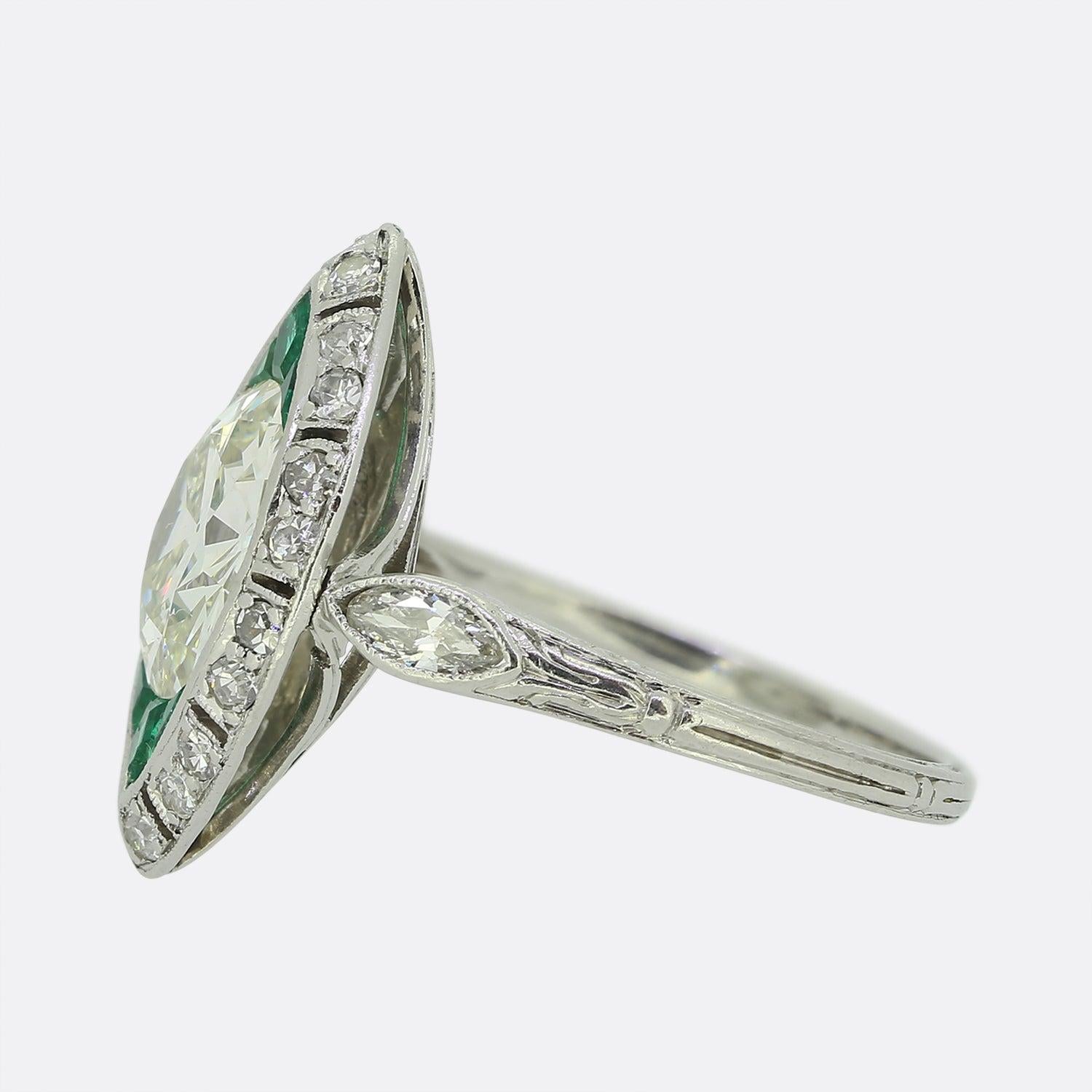 Here we have an outstanding emerald and diamond navette ring, crafted at a time when the Art Deco style was at the height of design.

An impressive 2.30ct old cut diamond sits at the centre of the face whilst being top and tailed by a trio of