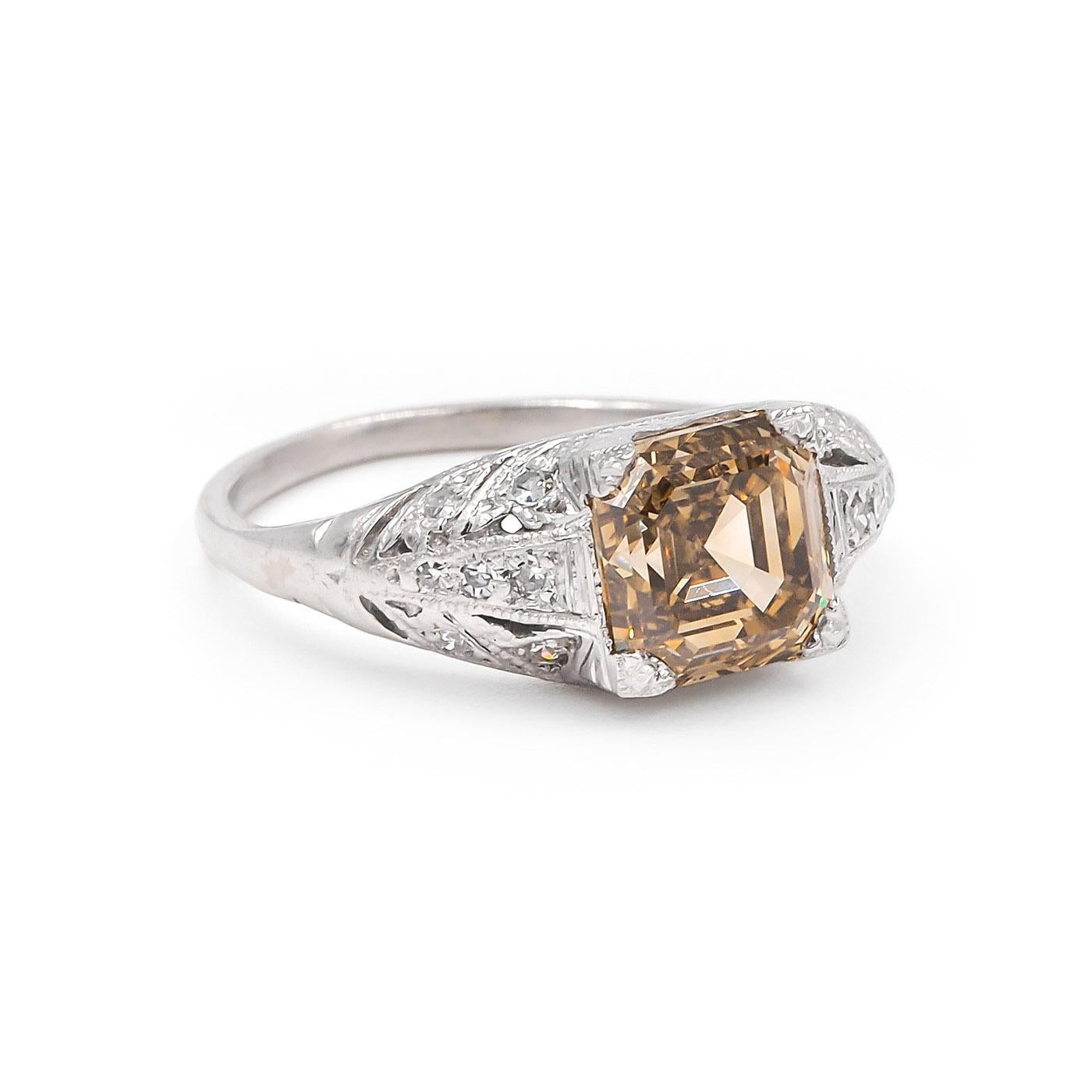 Art Deco era 2.38 Carat Natural Fancy Brown-Yellow Asscher Cut Diamond Engagement Ring, composed of platinum. Centering on a 2.38 carat Asscher Cut diamond, GIA certified Natural Fancy Brown-Yellow color & VS2 clarity. With an additional 14 Single