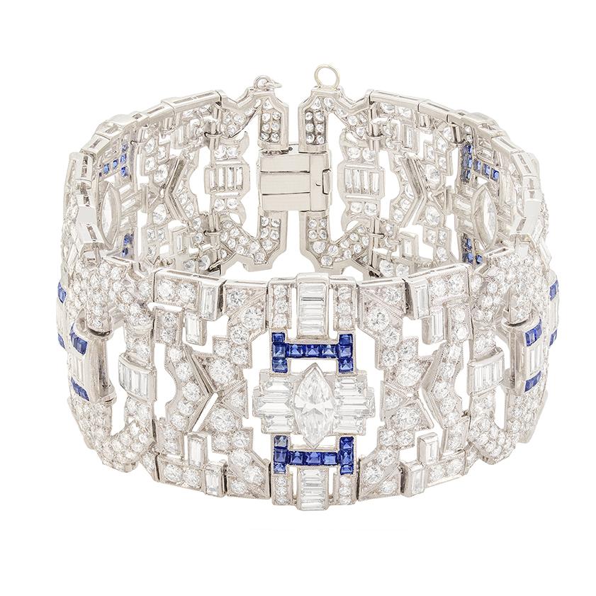 Dieses exquisite Art-Déco-Armband mit Diamanten und Saphiren ist ein wahrer Blickfang. Drei große Diamanten im Marquise-Schliff sitzen in der Mitte der jeweiligen Abschnitte,  ergänzt durch drei Diamanten im Baguetteschliff auf jeder Seite. Jeder