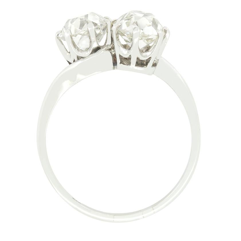 A pair of sparkling old cut diamonds take centre stage in this Toi et Moi, two stone ring from the Art Deco era. Each diamond weighs 1.20 carat and is claw set into a refined platinum collet. The pair range in colour from J to K and match in clarity
