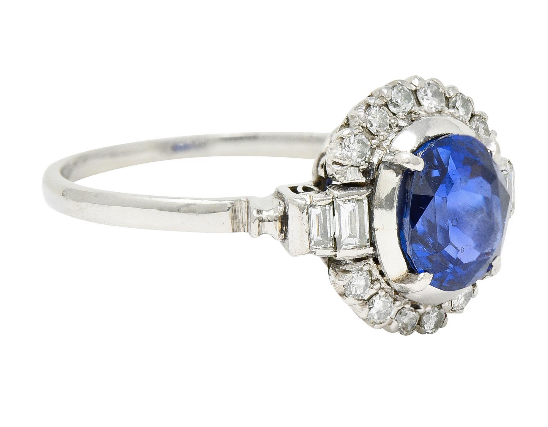Cluster ring centers an oval cut Burmese sapphire weighing 2.04 carats

Vibrant and uniform royal blue color with no indications of heat

Flanked by stepped shoulders bar set with rectangular step cut diamonds

With a partial round brilliant cut