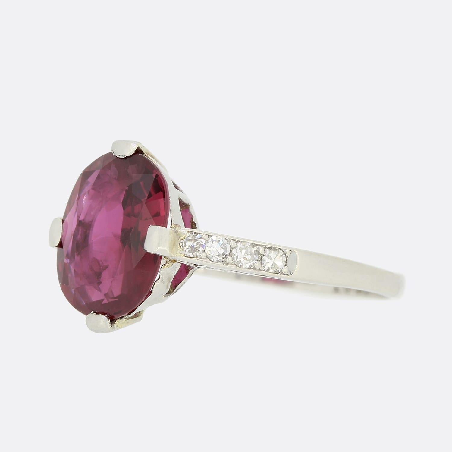 This is a wonderful Art Deco, ruby and diamond solitaire ring. The oval ruby exuberates character and the deep red tone is highly complimented by the bright white diamond shoulders. The ring would have been entirely made by hand in the 1930s and