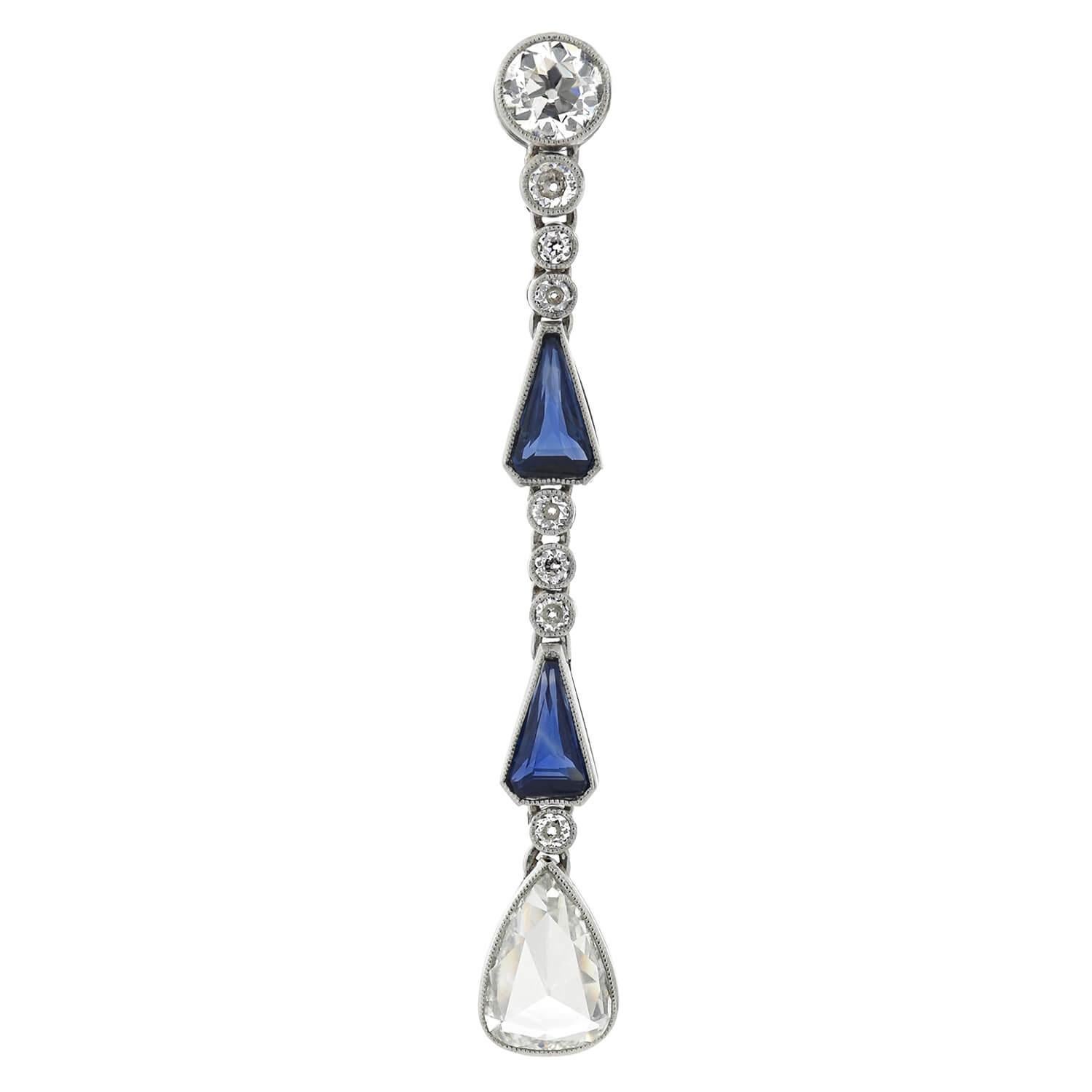 A stunning pair of diamond and sapphire earrings from the late Art Deco (1930s) era. Crafted in platinum, each earring displays eight sparkling diamonds and two vibrant sapphires, all resting within fine milgrained bezel settings. The earrings