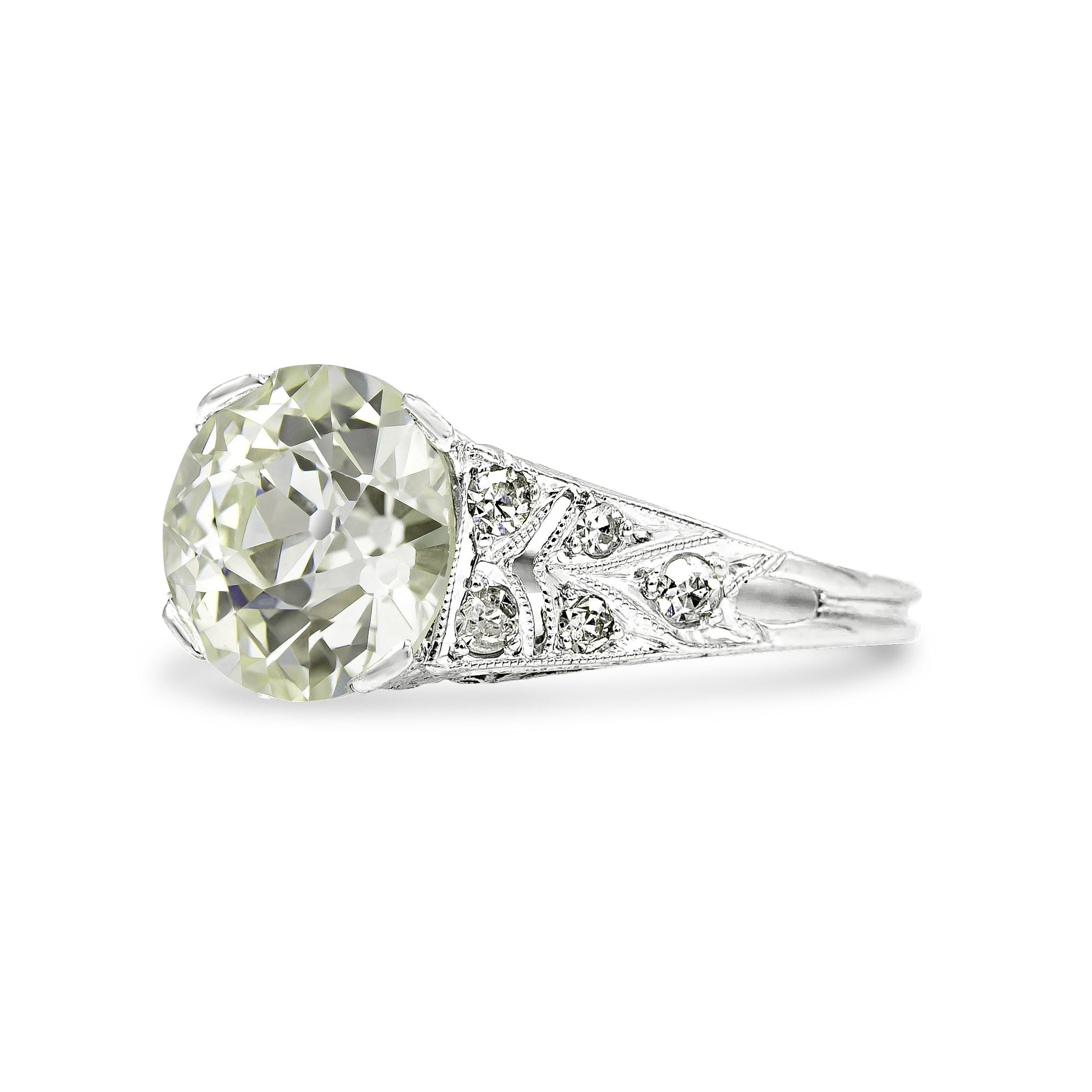 Charmed, we’re sure. That’s certainly how you’ll feel when you slip this Art Deco engagement ring onto your finger. Hand-crafted with openwork design, her elegance is a true example of old world artisanship and style. Centered in her crown is a 2.49