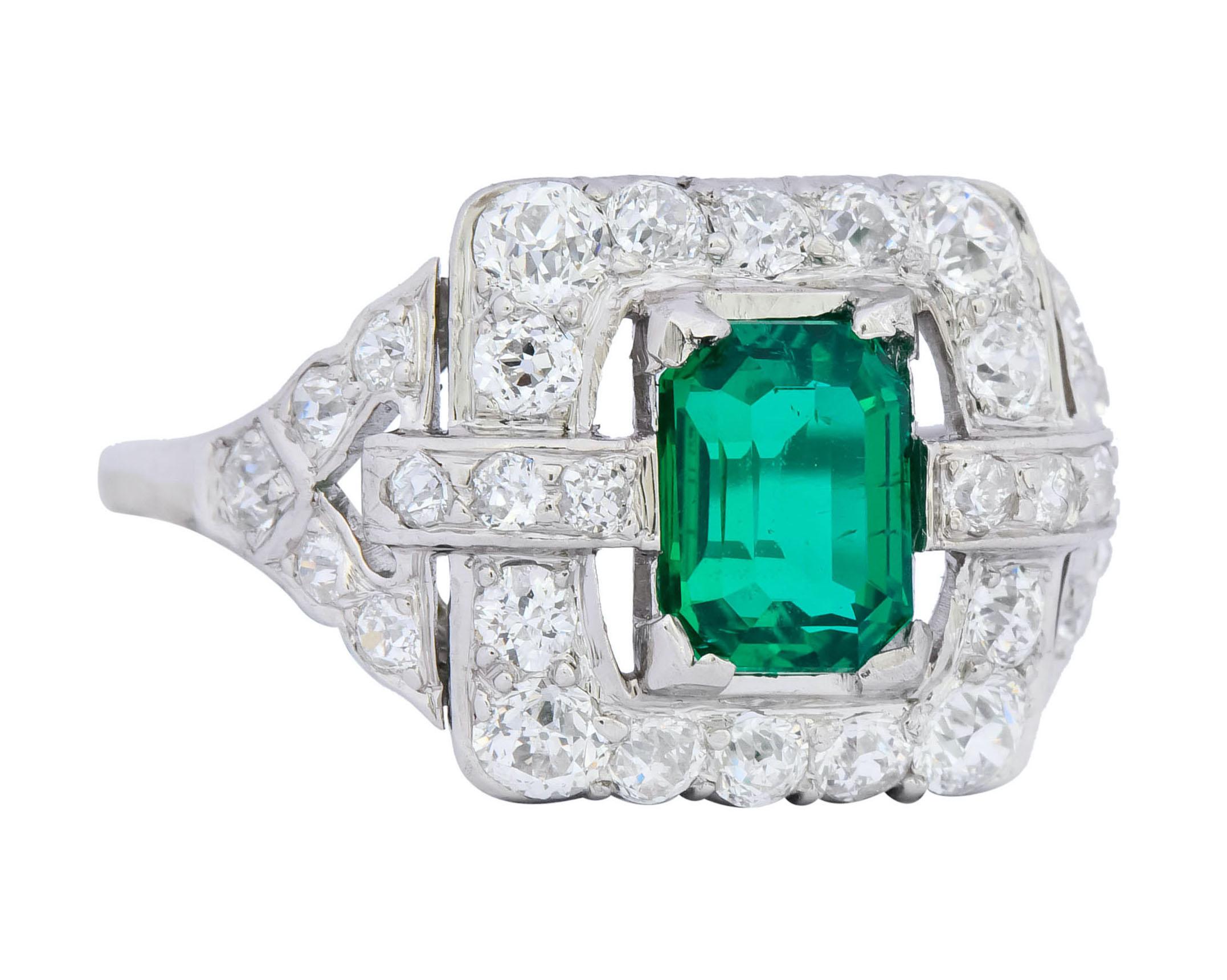 Centering an emerald cut Colombian emerald weighing 1.11 carats, transparent and a very saturated green color with minor clarity enhancements

With a halo surround and a split shank set throughout with old European cut diamonds weighing