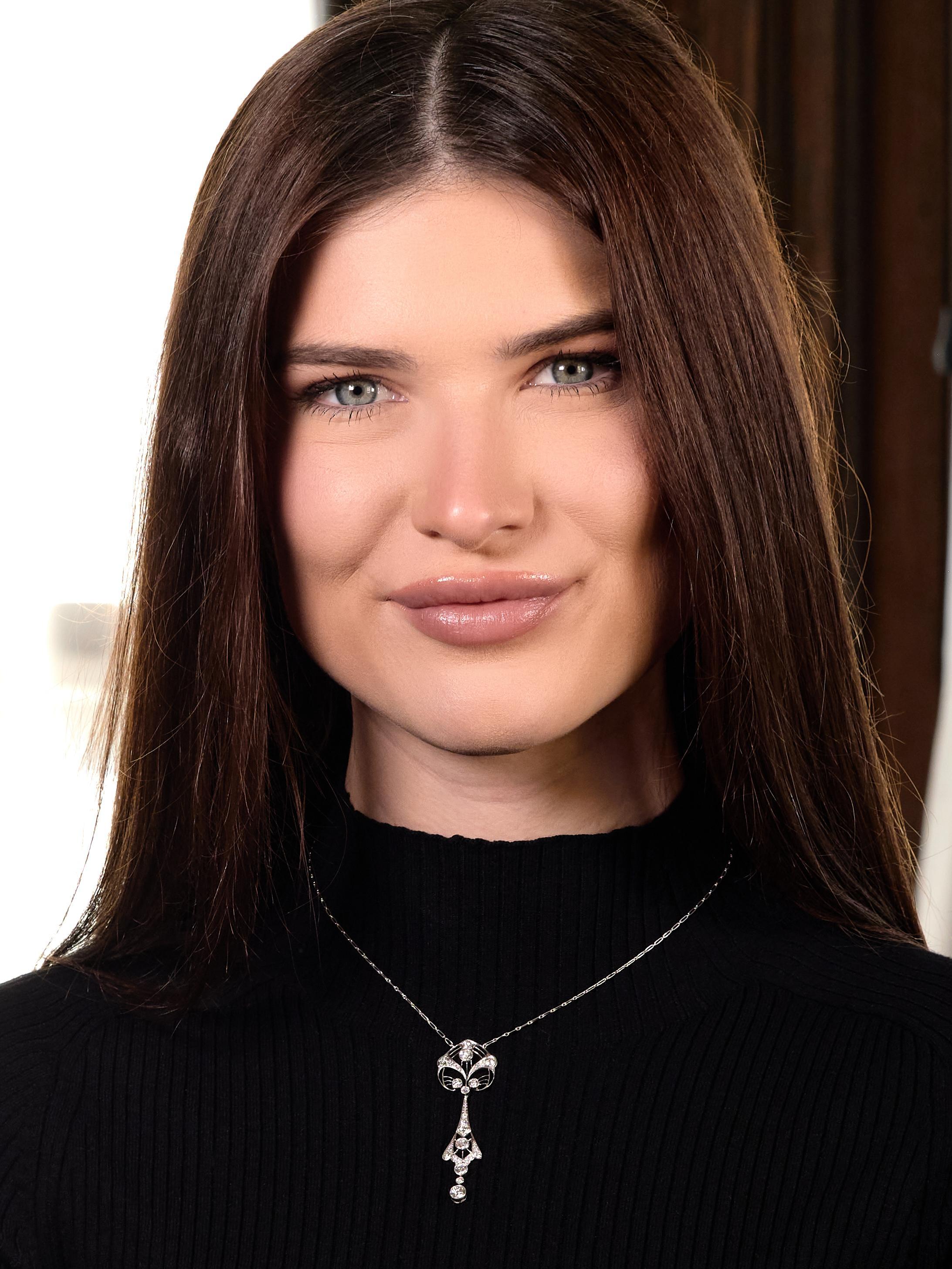 Designed as paperclip link chain centering a pendant drop station
Comprised of pierced scrolling lily pad with cartouche drop
Featuring old European cut diamonds bead set throughout
With additional diamonds bezel set throughout and as drop
Weighing