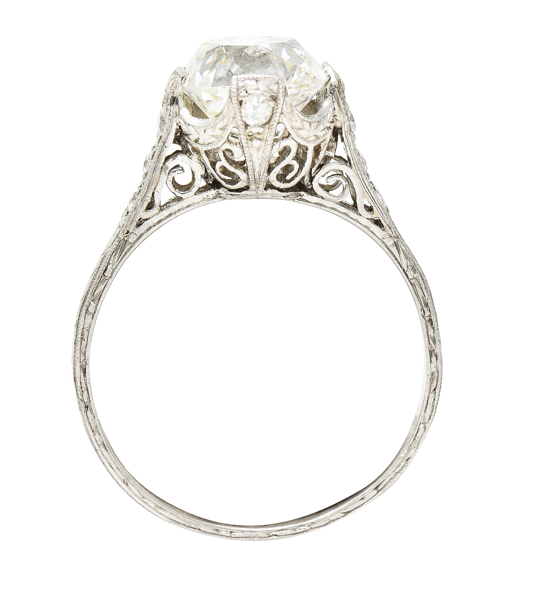 Featuring an old mine cut diamond weighing 2.58 carats - J color with VS1 clarity. Set by decorative wide prongs in a pierced head with a deeply swagged basket edge. Flanked by cathedral shoulders accented by single cut diamonds. Weighing in total