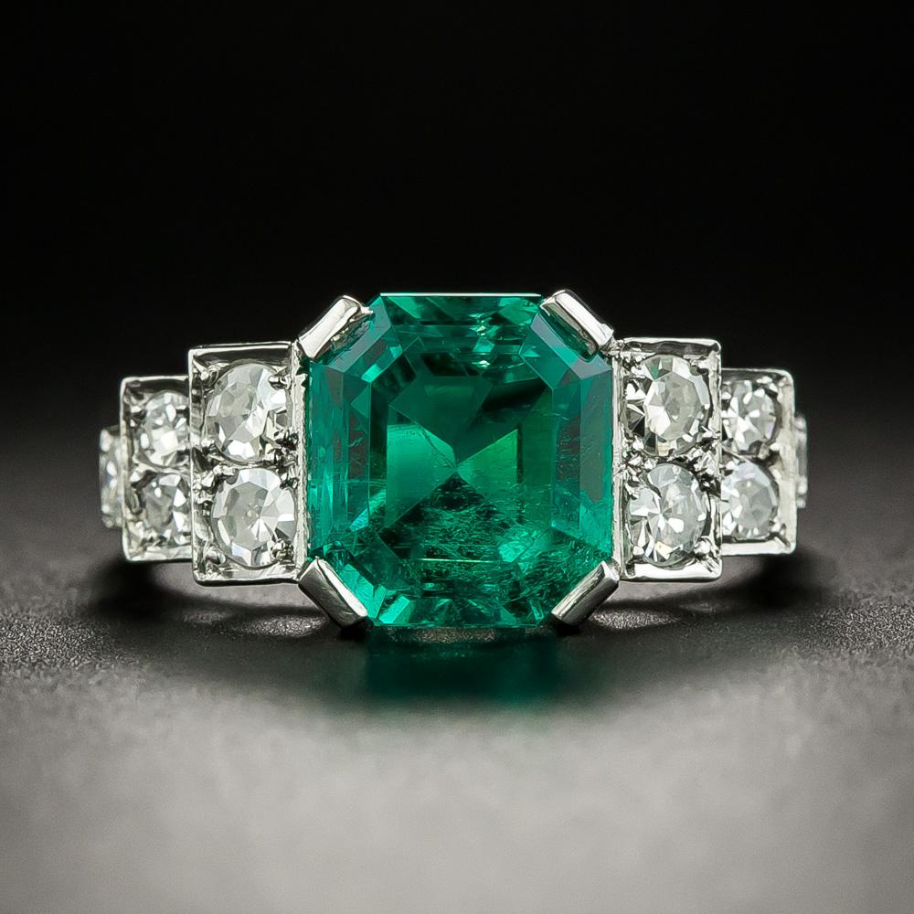 A rare, resplendent and utterly enchanting Colombian emerald, weighing 2.81 carats, radiates a gorgeous crystalline green glow from between sparkling diamond-set stepped shoulders in this magnificent vintage stunner hand fabricated in platinum -