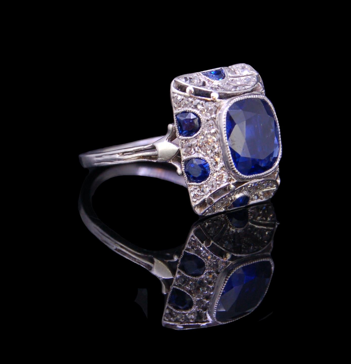 ART-DECO STYLE 2.83 ct. BURMA BLUE SAPPHIRE AND DIAMOND PLATINUM RING, set with a cushion cut sapphire of 2.83 ct. in a bevelled and concave rectangular surround set with round cut diamonds and fancy cut sapphires. French assay marks. Size M. 5.7