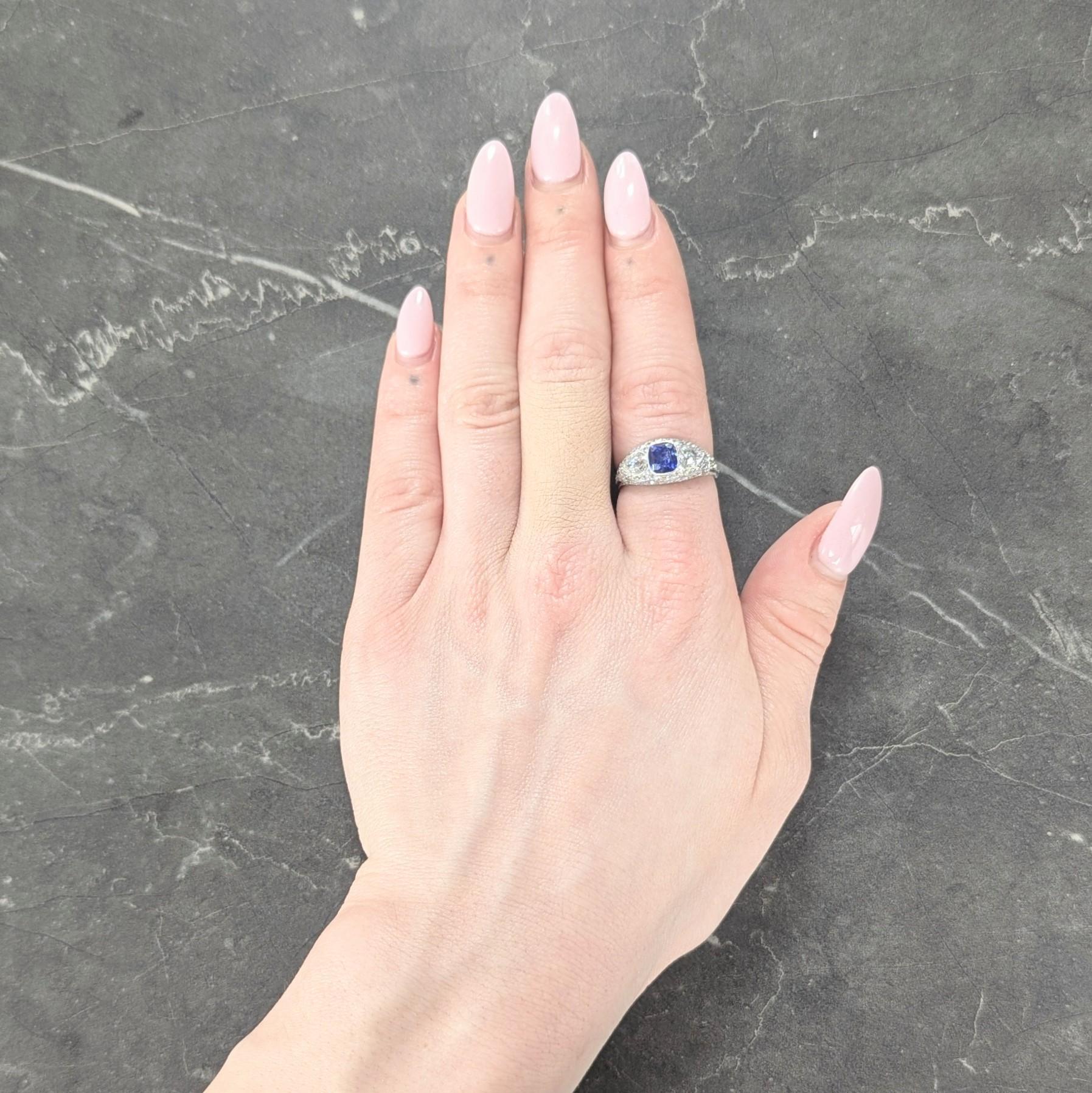 Centering a cushion cut sapphire weighing approximately 1.35 carats - transparent medium blue
Natural Ceylon (Sri Lankan) in origin with no indications of heat treatment
Bezel set to front and flanked east to west by bezel set pear cut