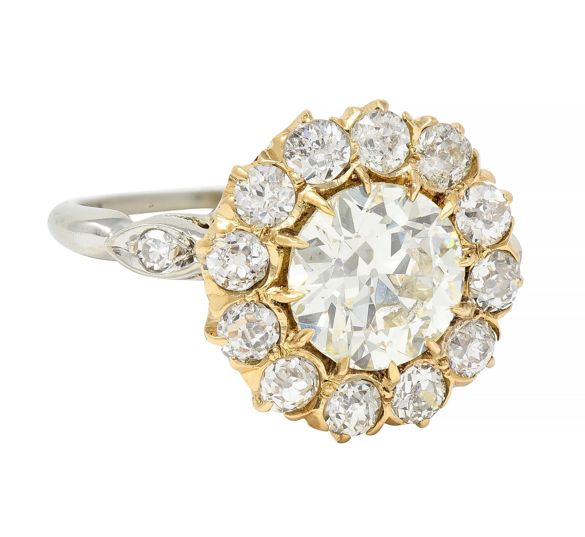 Centering an old European cut diamond weighing 1.95 carats - N color with VS2 clarity
Set with talon prongs in yellow gold gallery with halo surround
Comprised of additional old European cut diamonds 
Weighing approximately 0.96 carat total 
I to K
