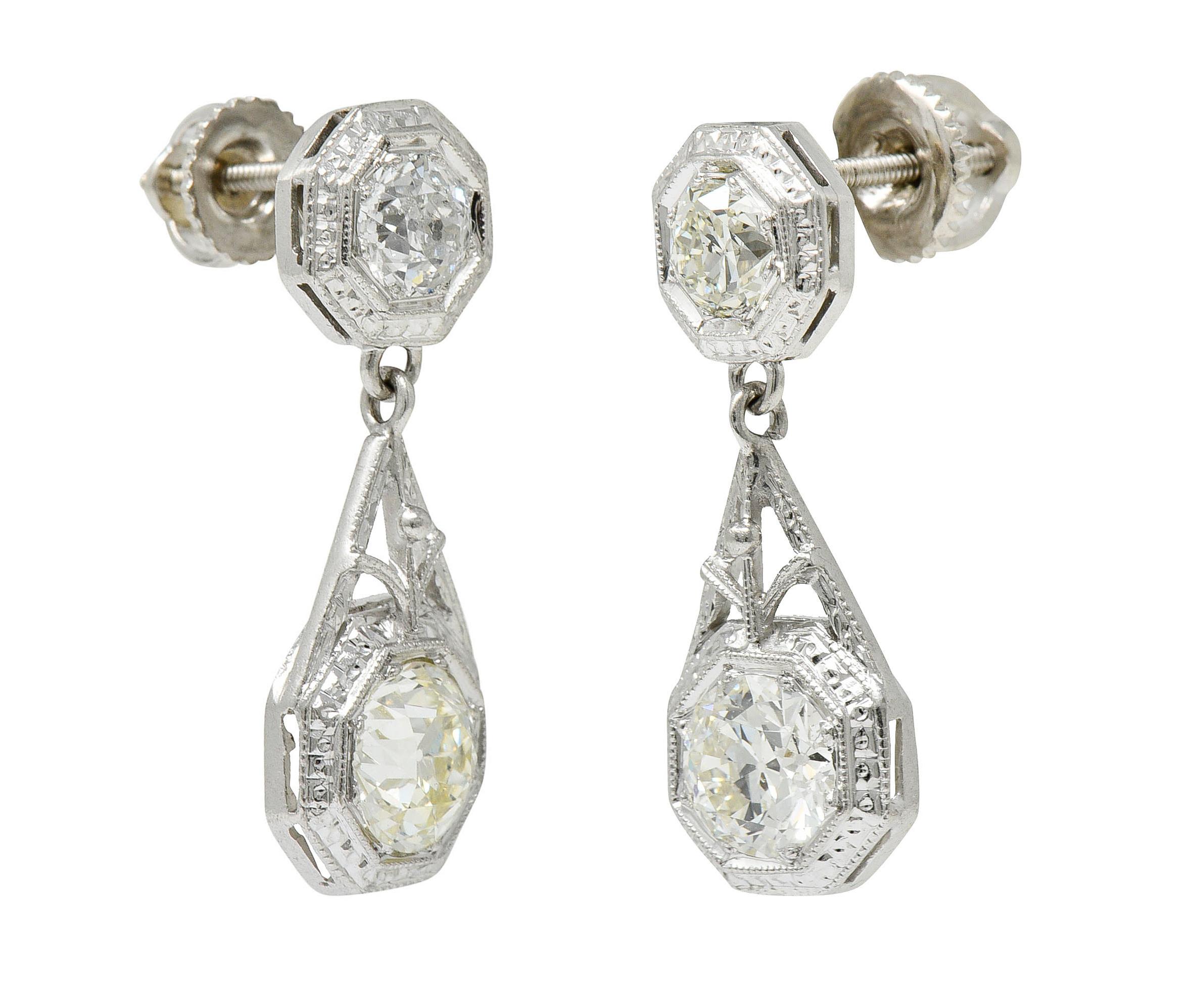 Earrings are designed with an octagonal surmount suspending a larger octagonal drop

Forms are deeply engraved and are accented by milgrain

Surmounts are set with two old European cut diamonds weighing in total approximately 0.90 carat

One