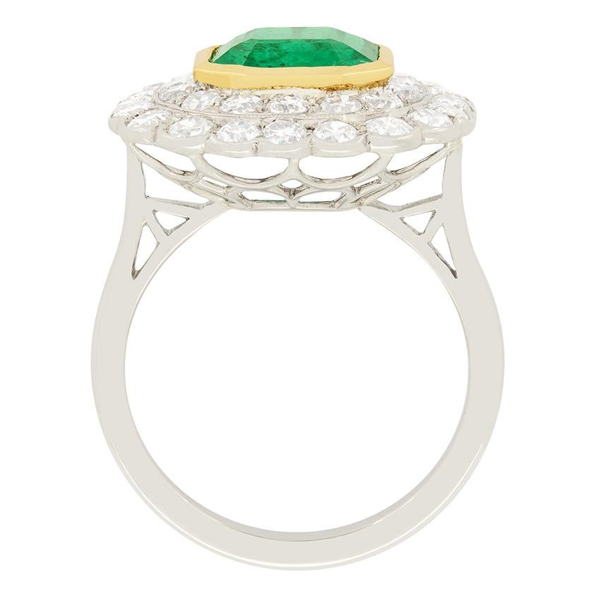 Surrounded by a double halo of transitional cut diamonds is a fantastic 2.97 carat, natural emerald of Columbian origin. Certified by The Gem and Pearl Lab, it has been characterized with minor oiling, a common occurrence to Emeralds. The