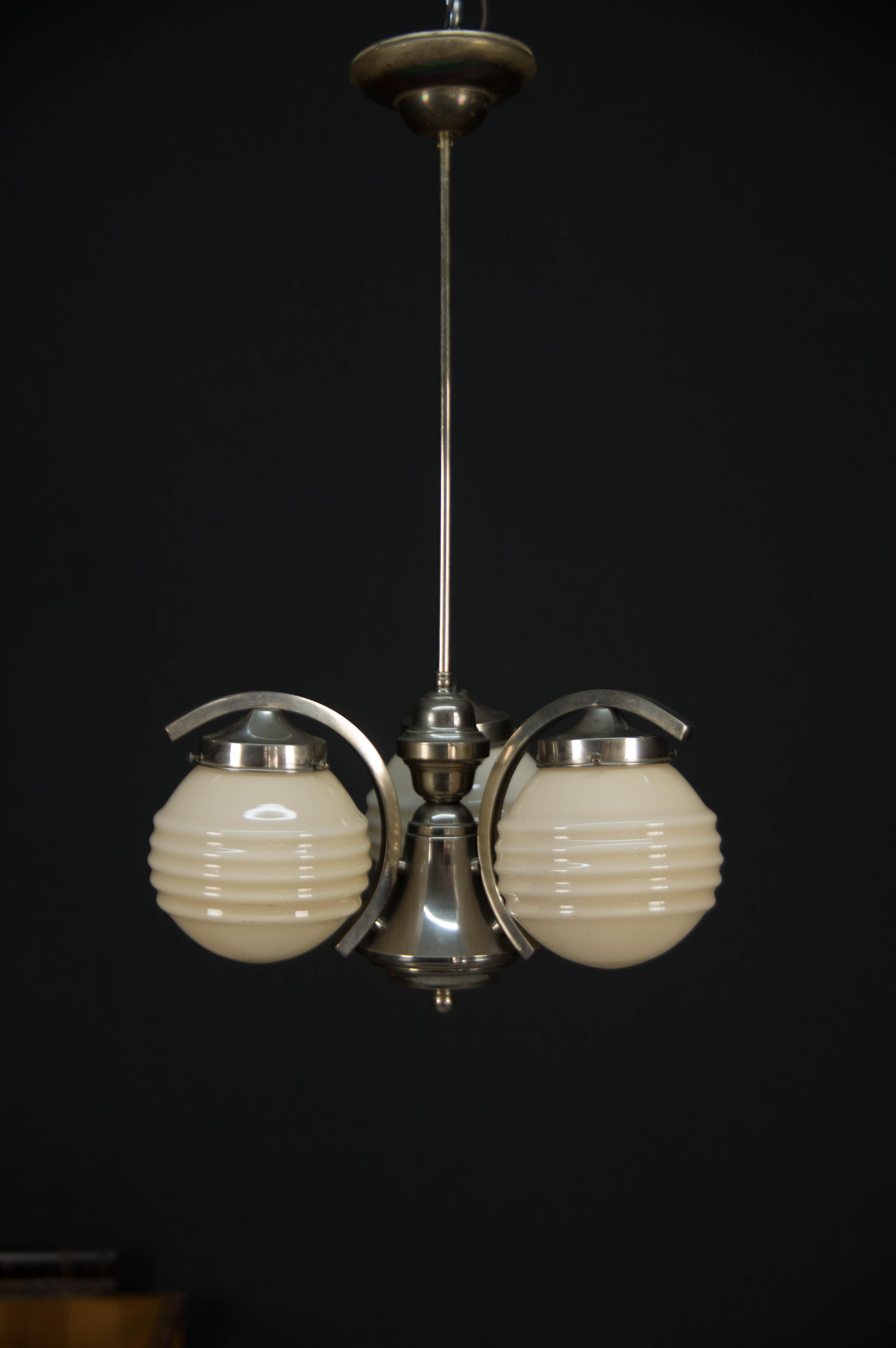 Chrome-plated Art Deco chandelier.
Original chrome with age patina - cleaned and polished
Original glass shades without damage
Rewired: 3x60W, E25-E27 bulb
US wiring compatible.
 