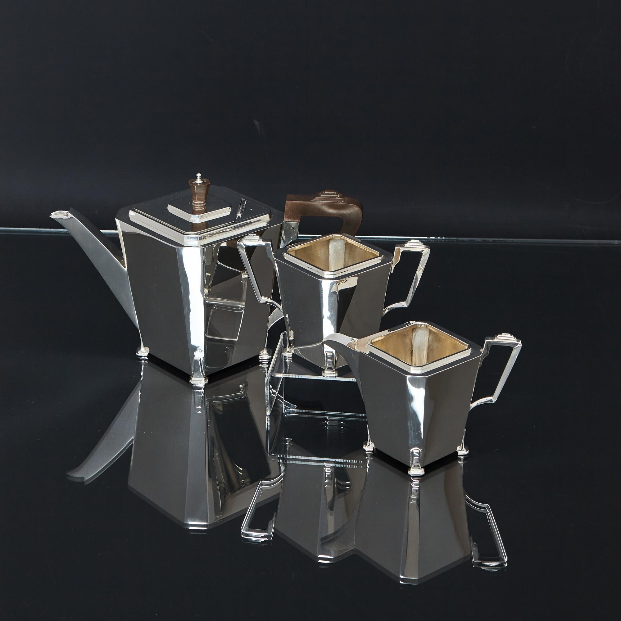 Very stylish three-piece Art Deco silver tea set with typical sleek lines of the era. All pieces of this handmade silver tea set feature geometric square panelled bodies with cut-corners, with handles on the corners to give a diamond shape. The