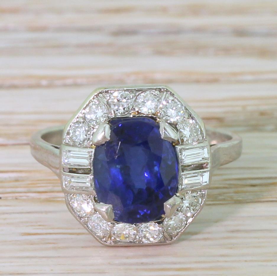 The most incredibly beautiful natural sapphire ring. The centre stone – a bright, lustrous royal blue – is secured by four square-ish claws in the centre of a magnificently crafted surround. Two pairs of baguette cut diamonds are set either side the