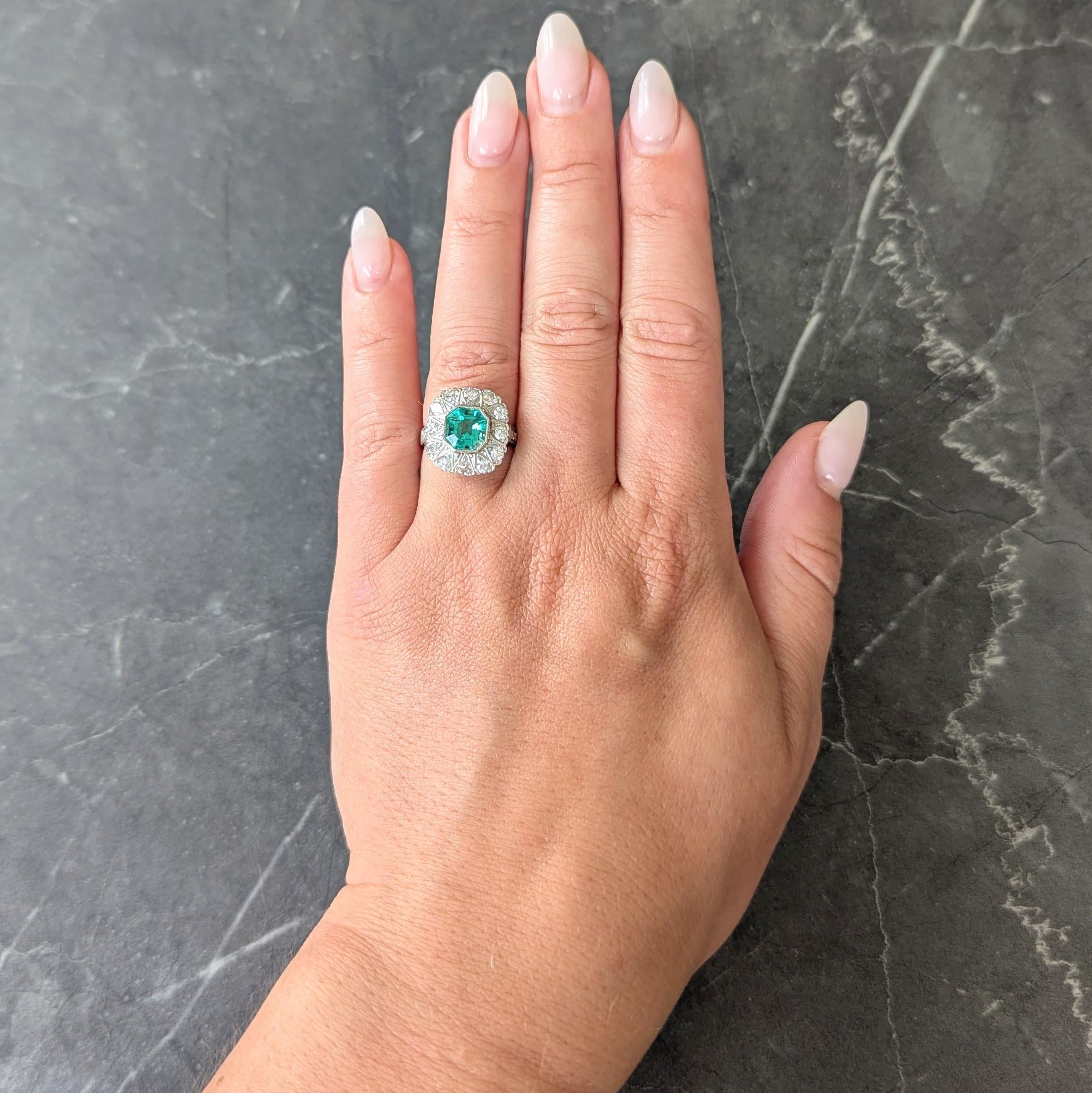 Al centro uno smeraldo taglio Asscher di circa 1,97 carati, di colore verde medio trasparente.
Nature di origine colombiana e che non presenta alcuna indicazione di miglioramento della chiarezza
Incastonato in un castone milgrain con un'aureola di