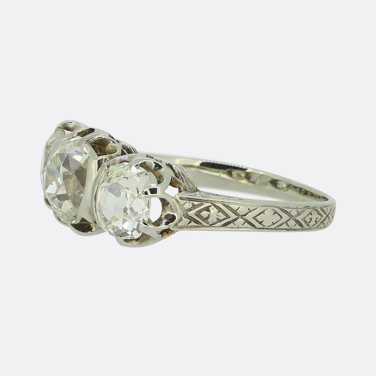 Nous avons ici une magnifique bague à trois pierres en diamant de l'époque Art déco. Cette pièce a été réalisée en or blanc 18ct et met en valeur trois diamants anciens de taille coussin. Le diamant central est d'une taille impressionnante de 1,60