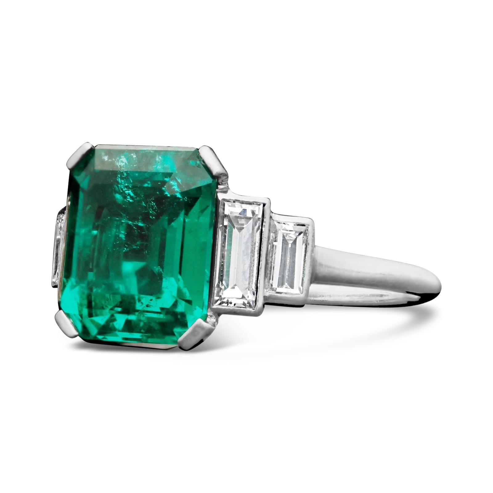 A stunning Art Deco emerald and diamond ring c.1925, centred with a beautiful 3.20ct Colombian emerald-cut emerald in corner-claw setting between shoulders set with stepped baguette cut diamonds, all in a handmade platinum mount.

3.30ct Colombian