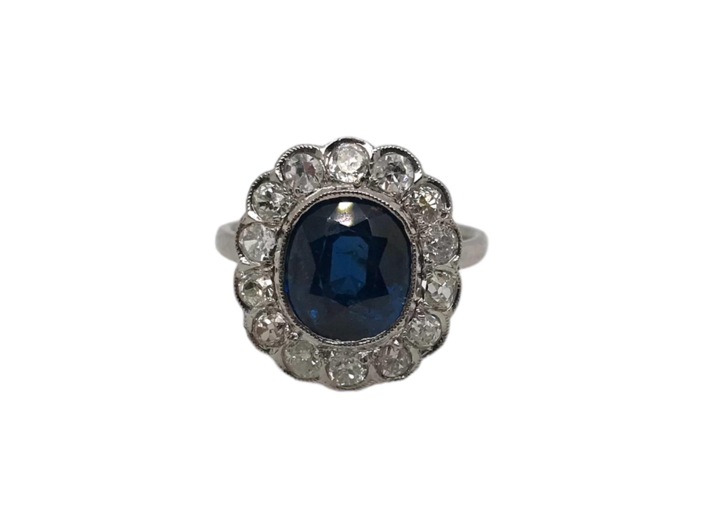 Cette beauté est un classique !
Fabriquée à l'époque de l'Art déco, entre 1920 et 1940, cette magnifique bague est ornée d'un saphir bleu entouré d'un ensemble de diamants de taille ancienne. 

Le saphir bleu est estimé à 3,25 carats et possède un