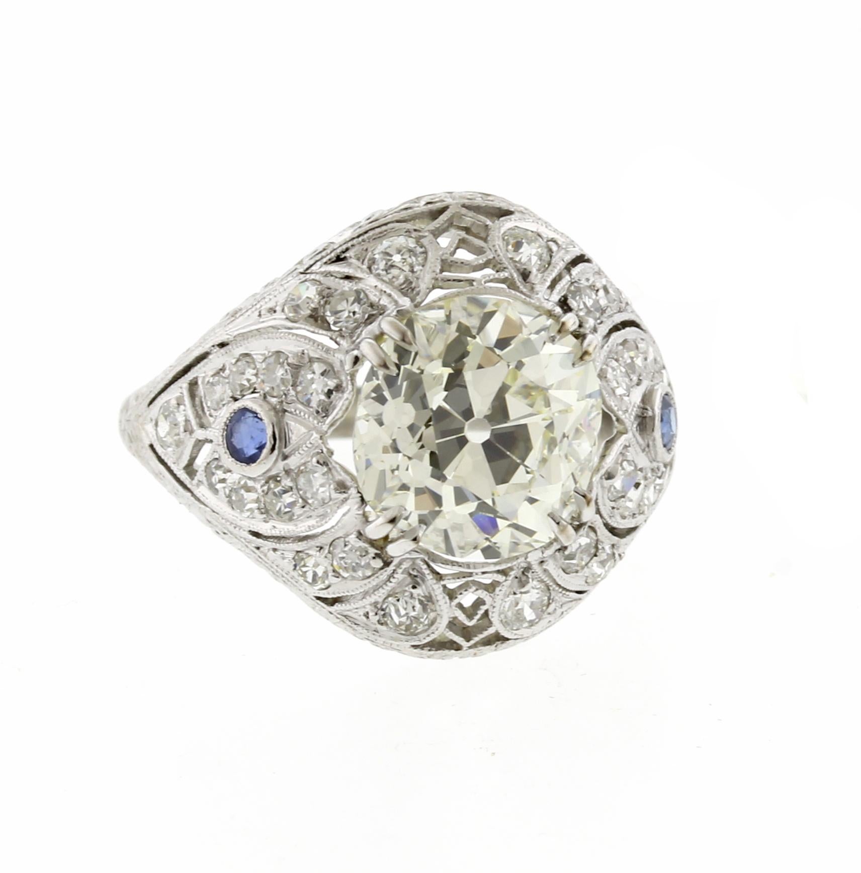 An exquisite example of Art Deco design. This hand made filigree ring boasts a 3.48 carat old European cut diamond. The G.I. A.  certified diamond is N color and VS1 clarity. The warm color radiants sparkle from every direction.  There are an