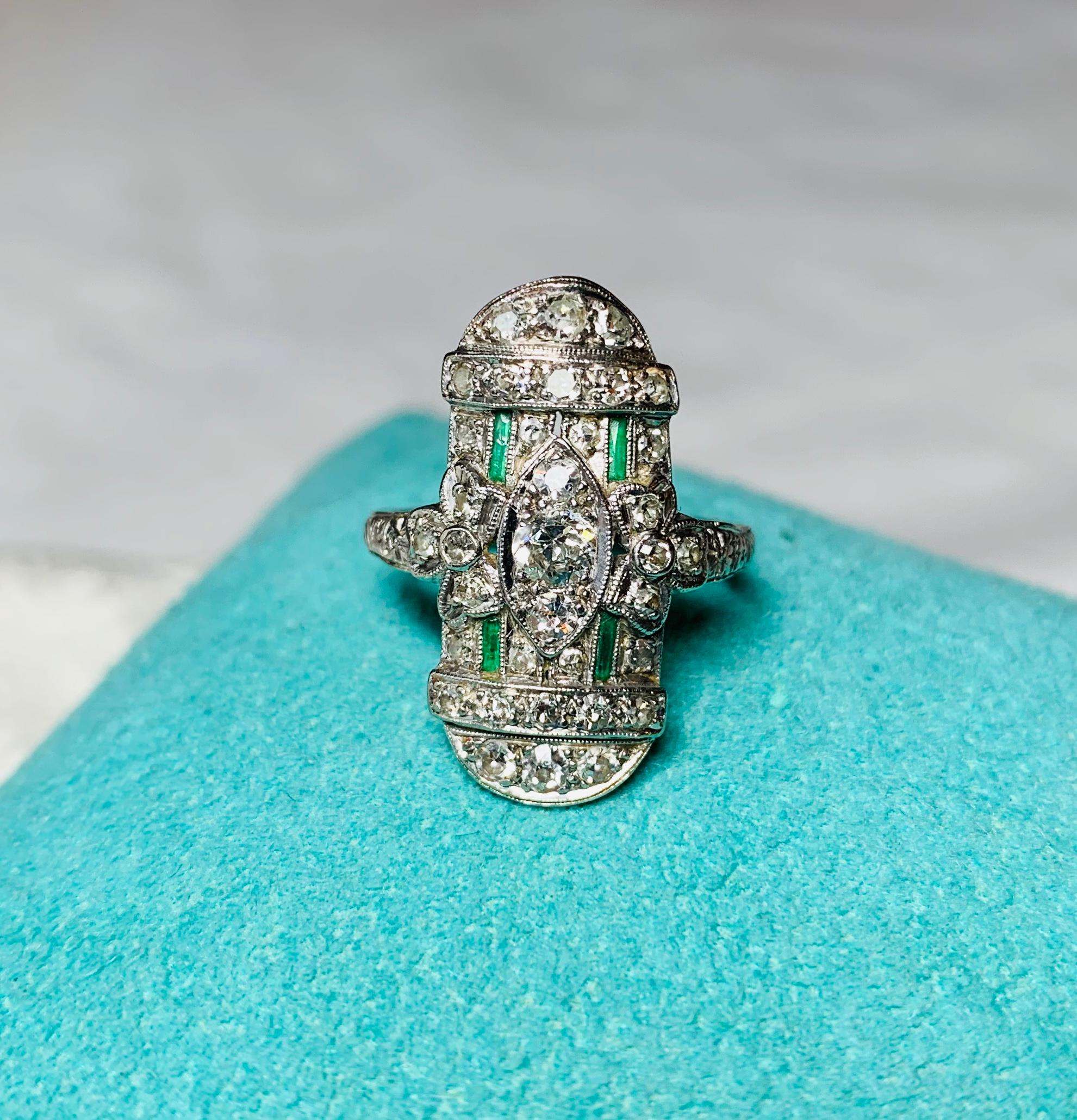 A stunning Antique Art Deco - Edwardian Diamond Ring set with 35 Old Mine Cut Diamonds and four Emeralds in Platinum.  The Art Deco, Edwardian jewels were characterized by the elegant use of Diamonds and Platinum.  It creates the airy, delicate,