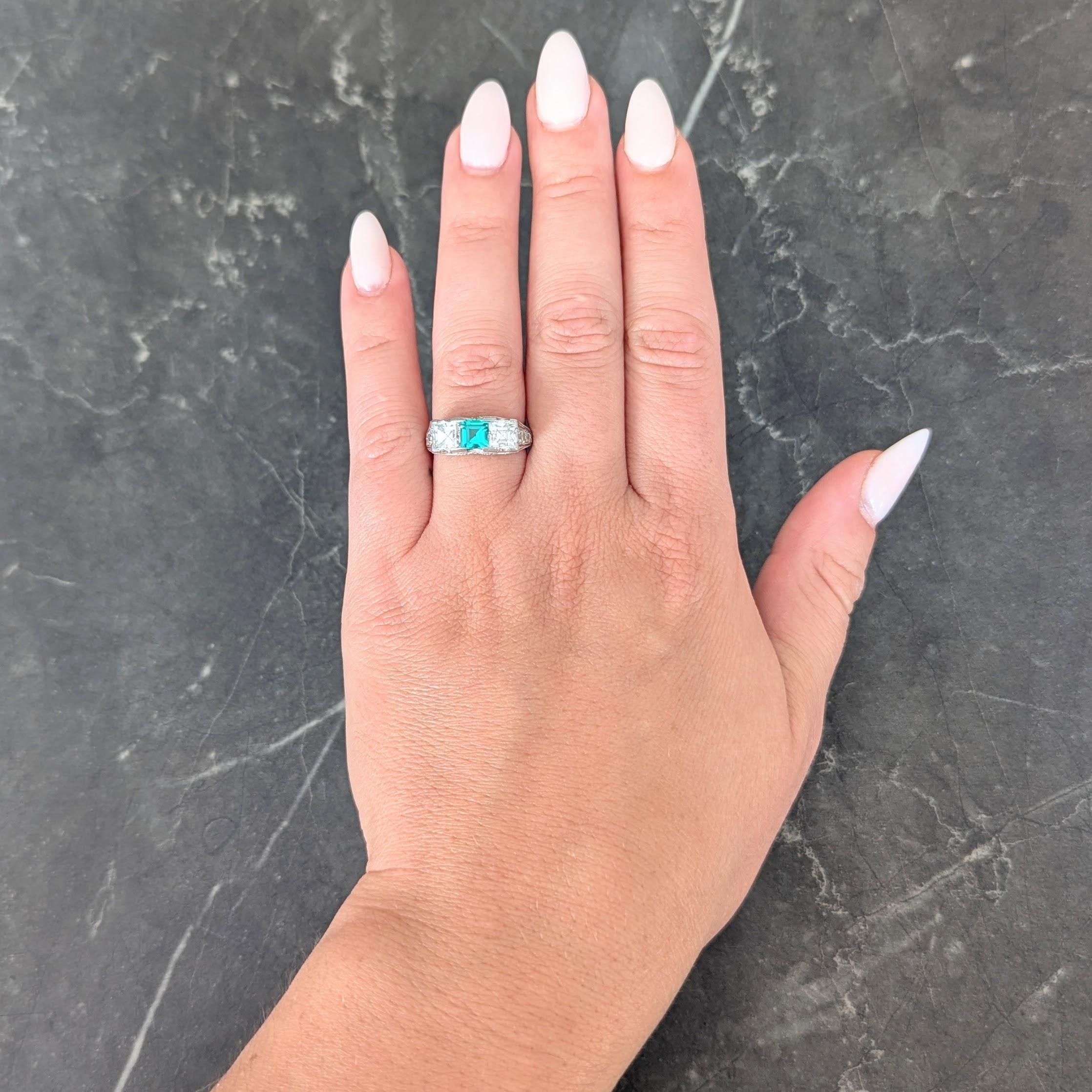 Centering a square step-cut emerald weighing approximately 0.59 carat
Transparent medium green and bar set with square step cut diamonds
Flanking east to west and weighing approximately 1.82 carats total
G color with VS2 clarity - accented by French