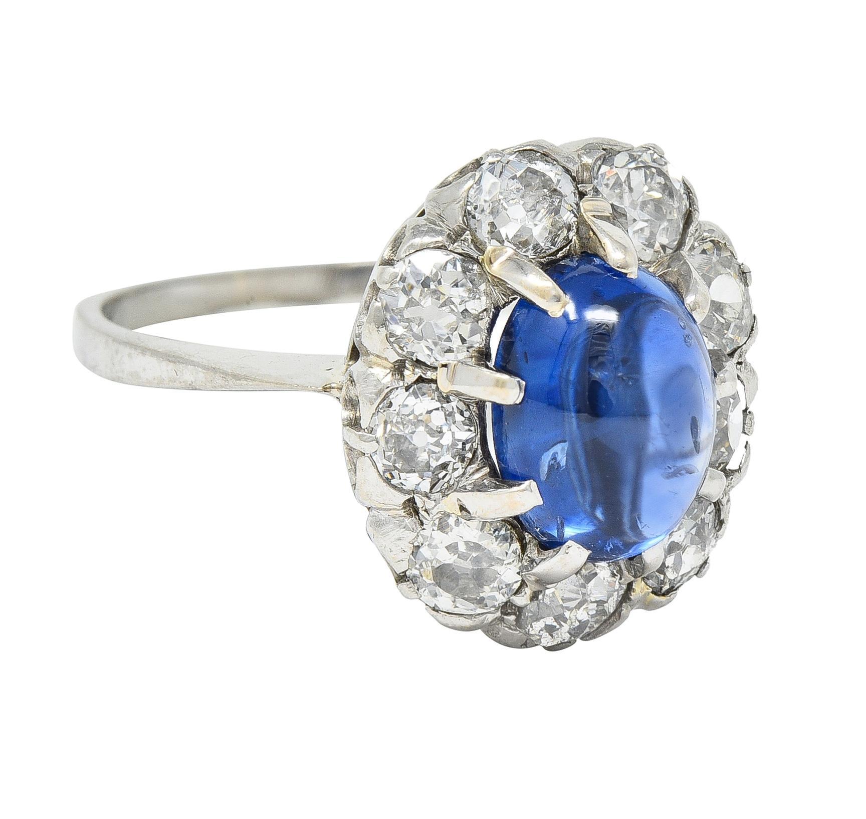 Centering an oval-shaped sapphire cabochon weighing approximately 2.44 carats 
Transparent medium blue in color - set with talon prongs with halo surround
Comprised of prong set old European and mine cut diamonds
Weighing approximately 1.08 carats