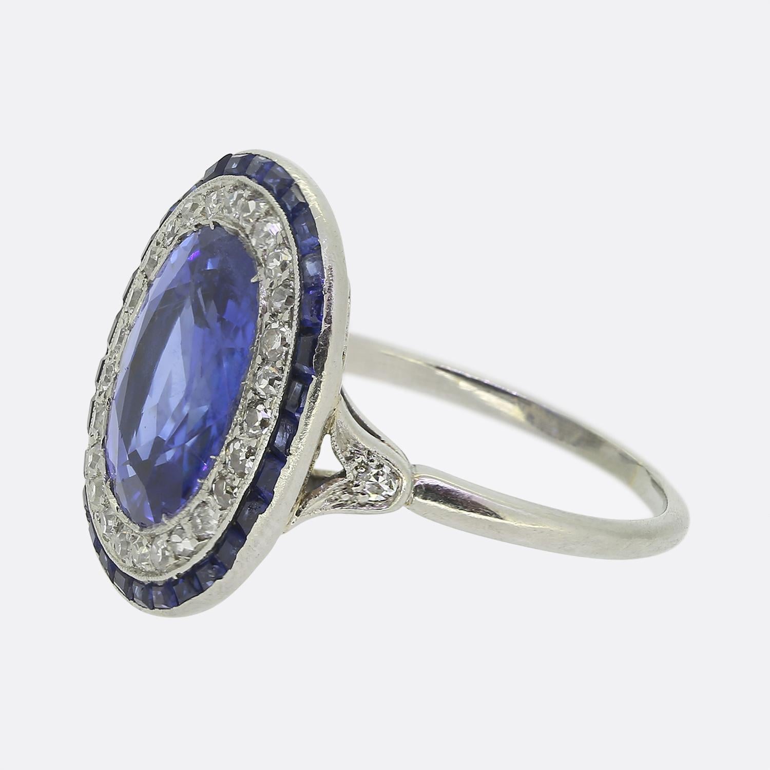 Nous avons ici une magnifique bague à grappes Art déco mettant en vedette un saphir naturel ovale facetté au centre de la face. Cette pierre à couper le souffle est d'origine birmane et possède une couleur bleue soyeuse et enjouée qui est complétée