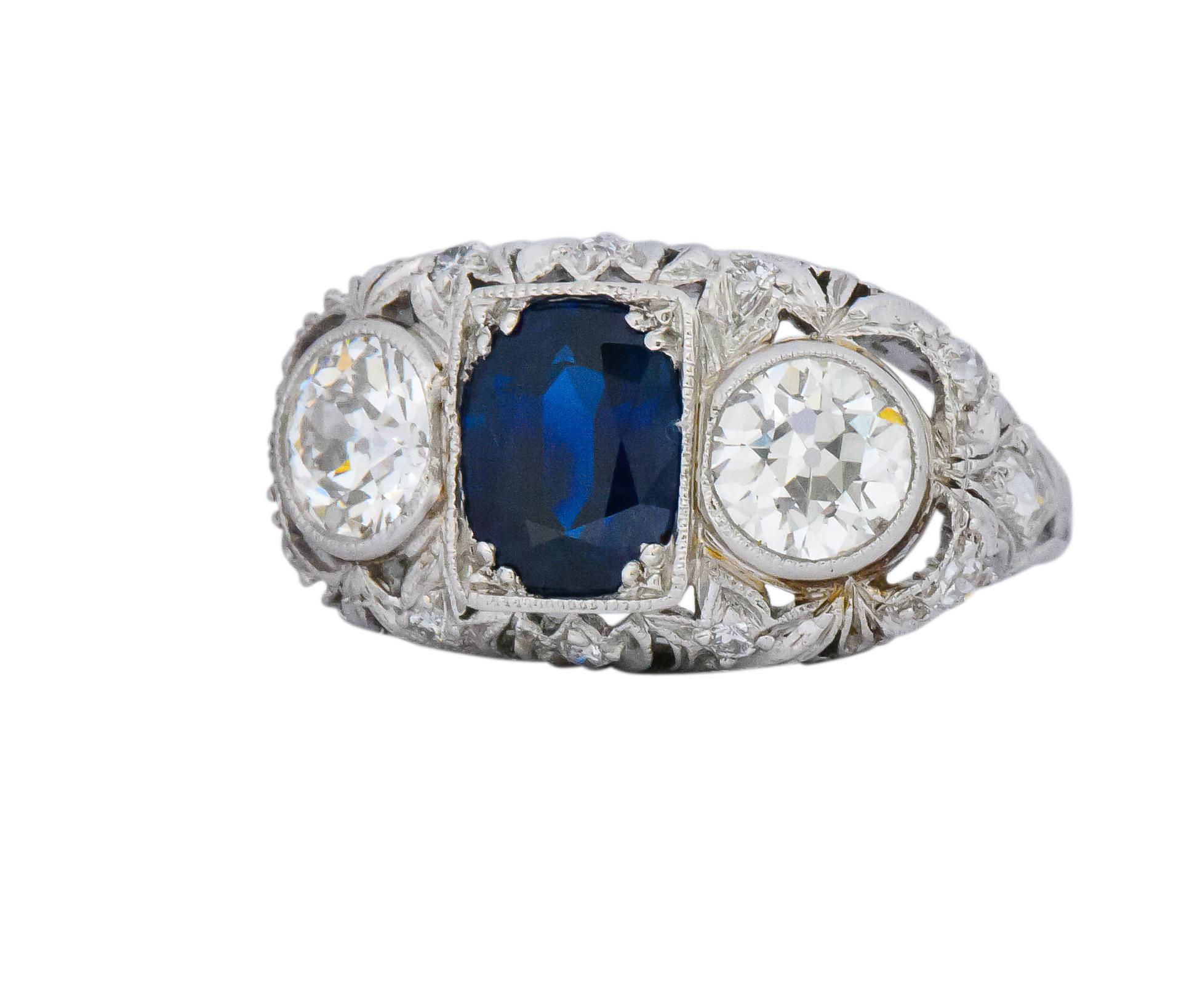 Centering an oval mixed cut sapphire weighing approximately 2.00 carats, bright deep blue, with no indications of heat treatment

Flanked by 2 old European cut diamonds weighing approximately 1.40 carats, H/I color and VS clarity

Accented with old