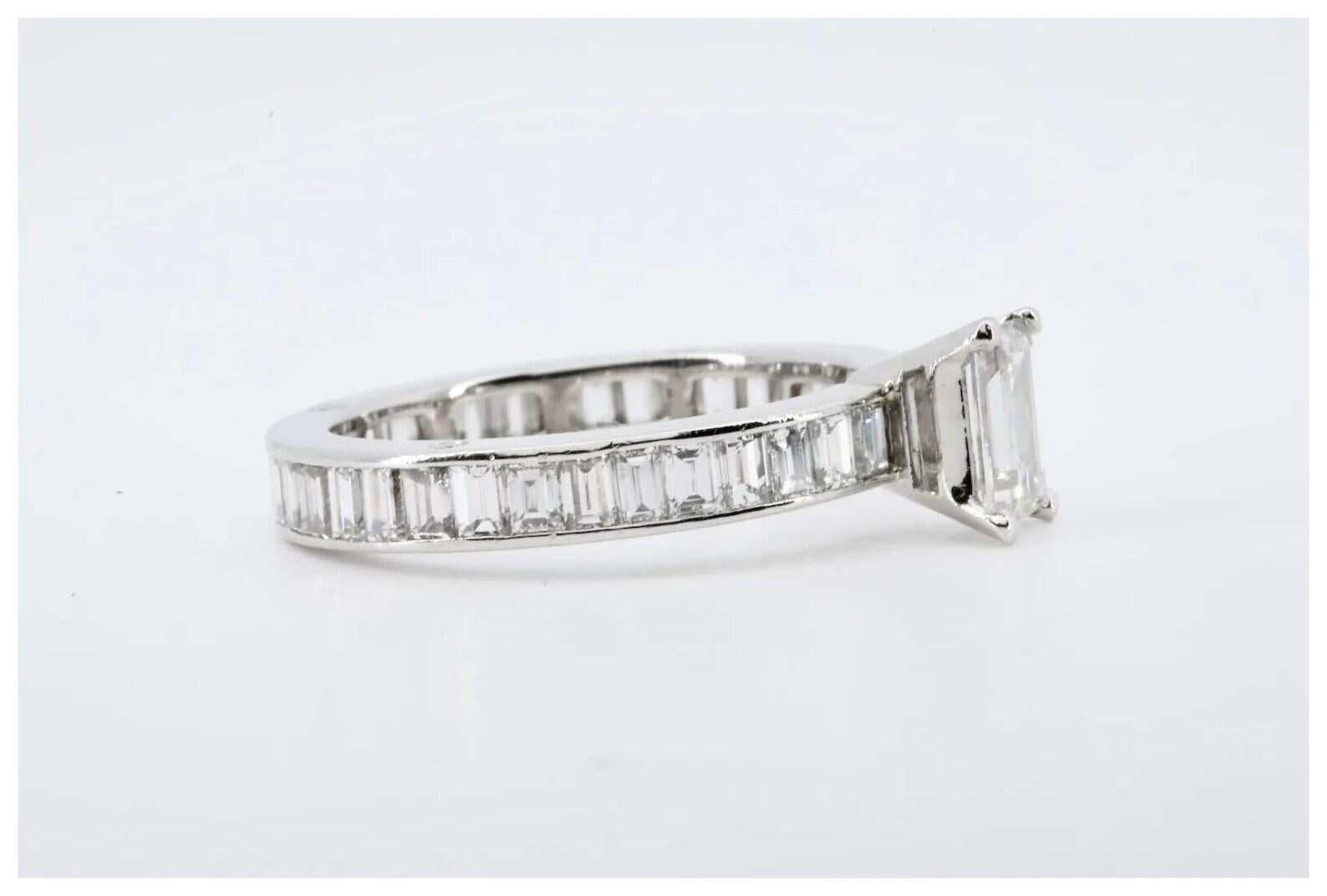 An Art Deco emerald cut diamond engagement ring in platinum, the band channel set with thirty eight further emerald cut diamonds.

Centered by a 0.85 carat emerald cut diamond of H color, and VS1 clarity.

The band set with 3.04 carats of H color VS
