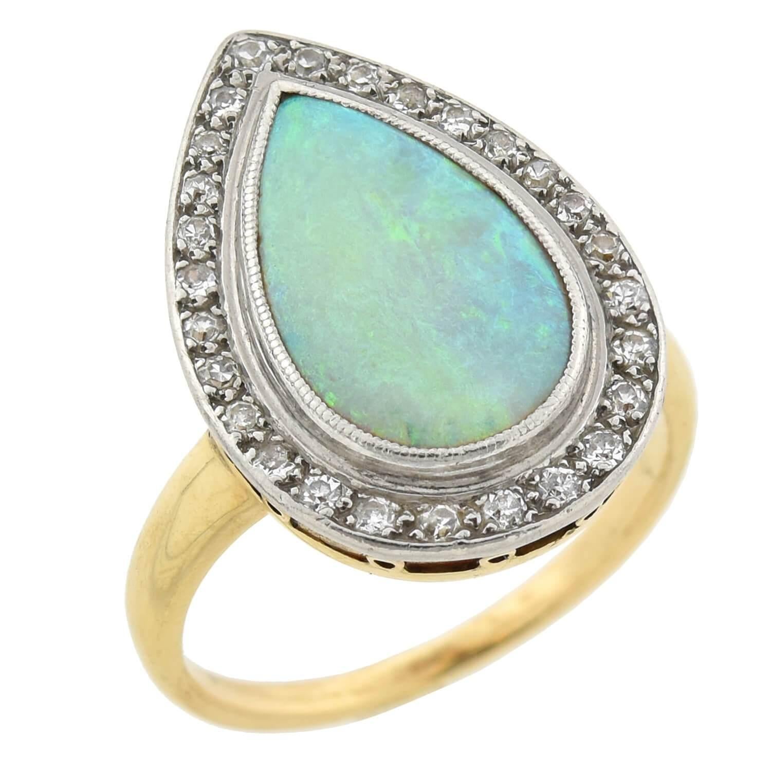 A stunning opal and diamond ring from the Art Deco (1920s) era! Crafted in 14kt yellow gold and platinum, this gorgeous piece stars a teardrop-shaped opal encircled by sparkling Single Cut diamonds. The vibrant opal, which has an approximate total