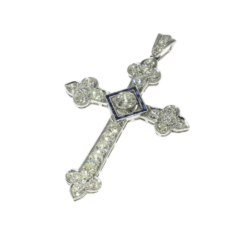 A fine Art Deco cross pendant in platinum set with a center old European cut diamond .60 carat (color and clarity: H/I, si/i), 27 old European cut diamonds totaling 3.40 carat (color and clarity: G/I, si/i) and 12 blue lab produced sapphires.