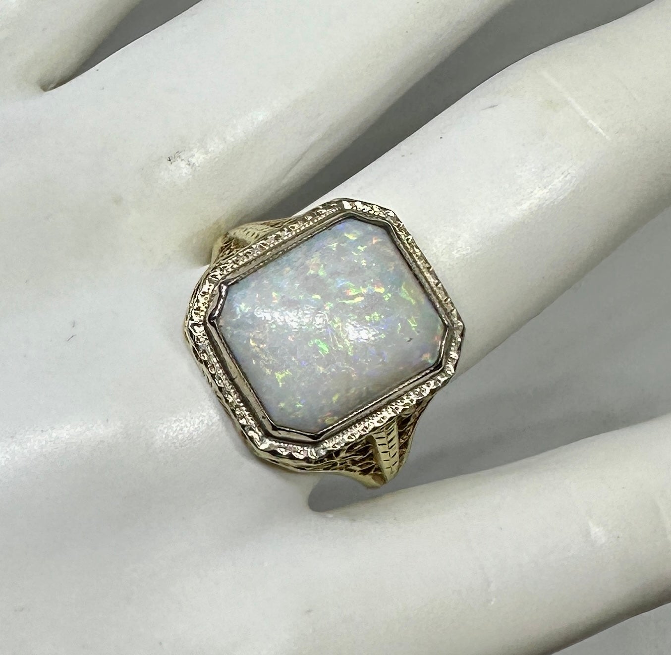 Indulge in a stunning Antique Art Deco - Hollywood Regency Opal Ring with a gorgeous central 4 Carat Opal set in a 14 Karat Rose Gold filigree open work setting of great beauty.  The spectacular oval opal cabochon gem has vivid red, yellow, orange,