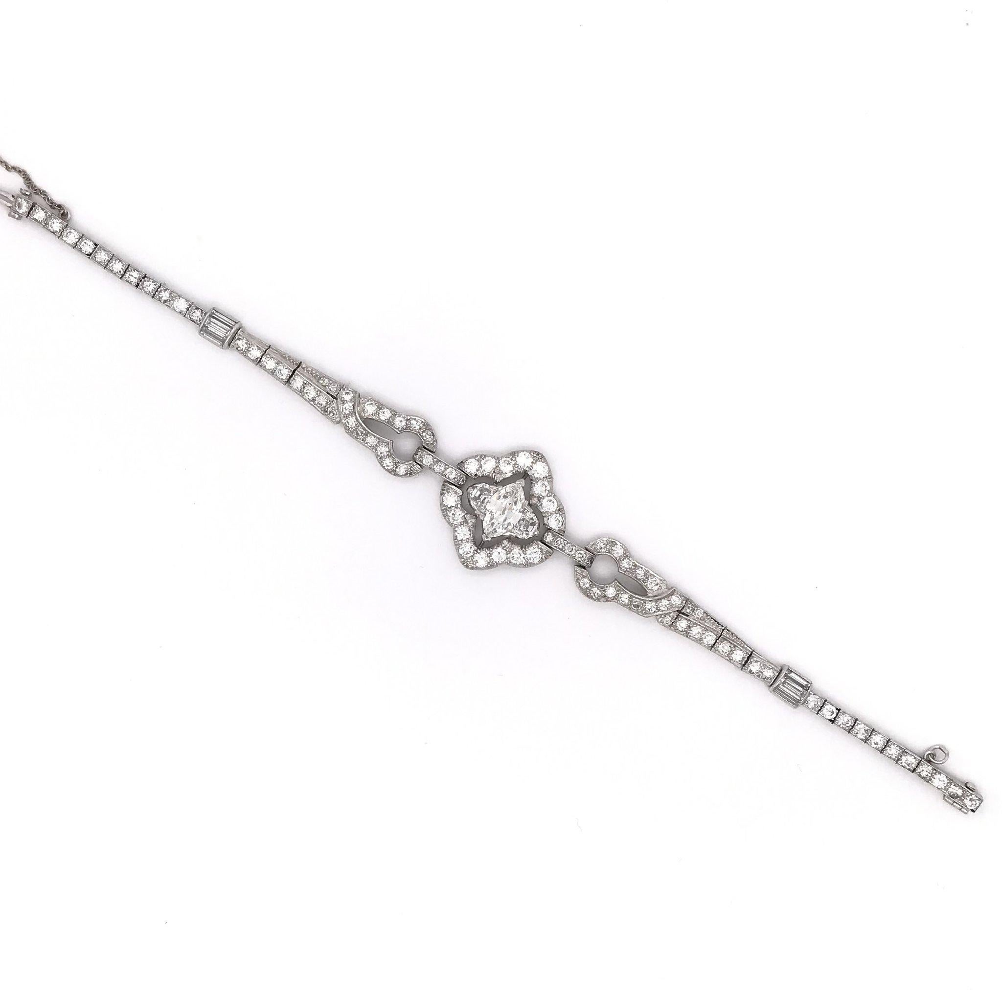This absolutely stunning antique diamond bracelet was handcrafted sometime during the Art Deco design period ( 1920-1940 ). The setting is platinum and features a beautiful marquise cut center diamond measuring approximately 0.75 carats. The center
