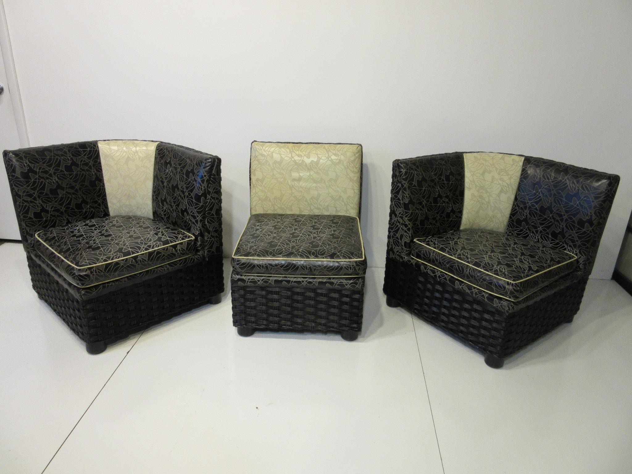 A three-piece love seat or sofa with black and white upholstered cushions with embossed amoeba styled designs. The frame is a painted black wraparound woven wicker with rounded wooden legs having spring supports for the seat cushions. The pieces can