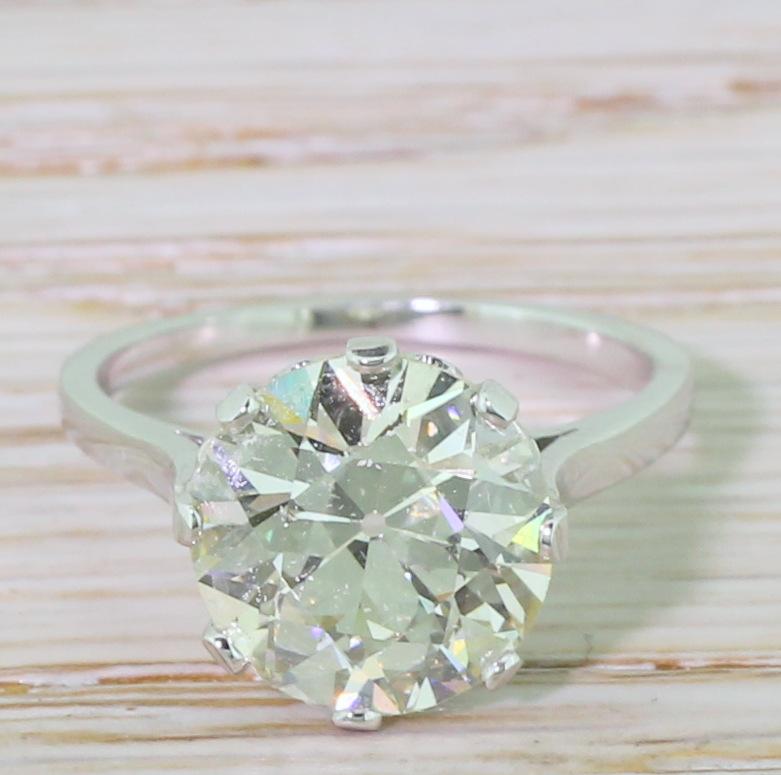 An awesome solitaire diamond ring. The huge old European cut – weighing in at an impressive 4.12 carat – displays a subtle champagne hue and is alive with fire and brilliance. The stone is showcased in lovely handmade mount, with eight claws and