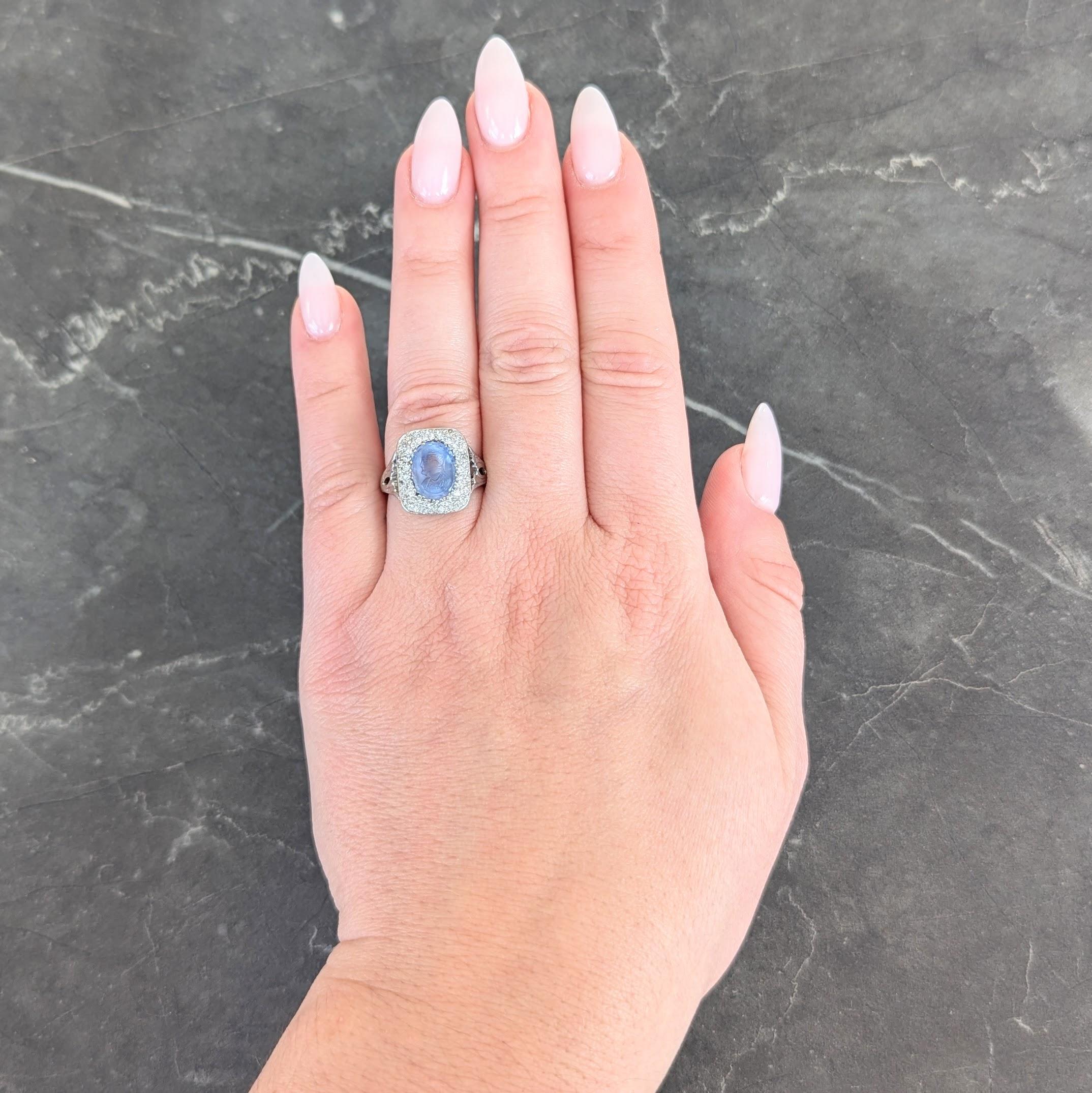 Centering an oval shaped mixed-cut sapphire weighing approximately 3.95 carats
Transparent light blue in color and depicting a cameo of Napoleon in profile
Bead set with a cushion shaped surround pavé set with diamonds
Old single cuts and weighing