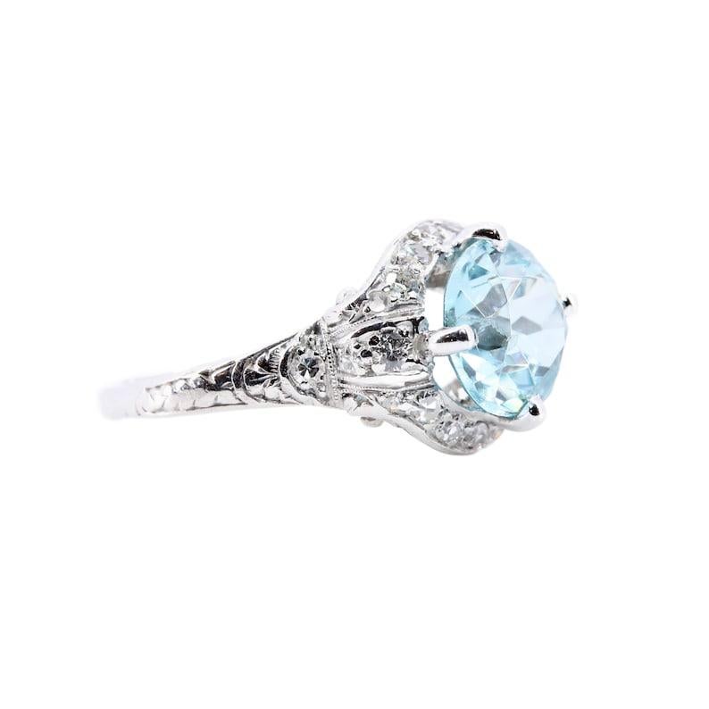 Aston Estate Jewelry Presents:

A classic Art Deco period blue zircon cocktail ring in platinum. Centered by a vivacious 4.05 carat blue zircon. Accented by 0.44ctw of pave set diamonds throughout with G color and VS clarity. Complemented by hand
